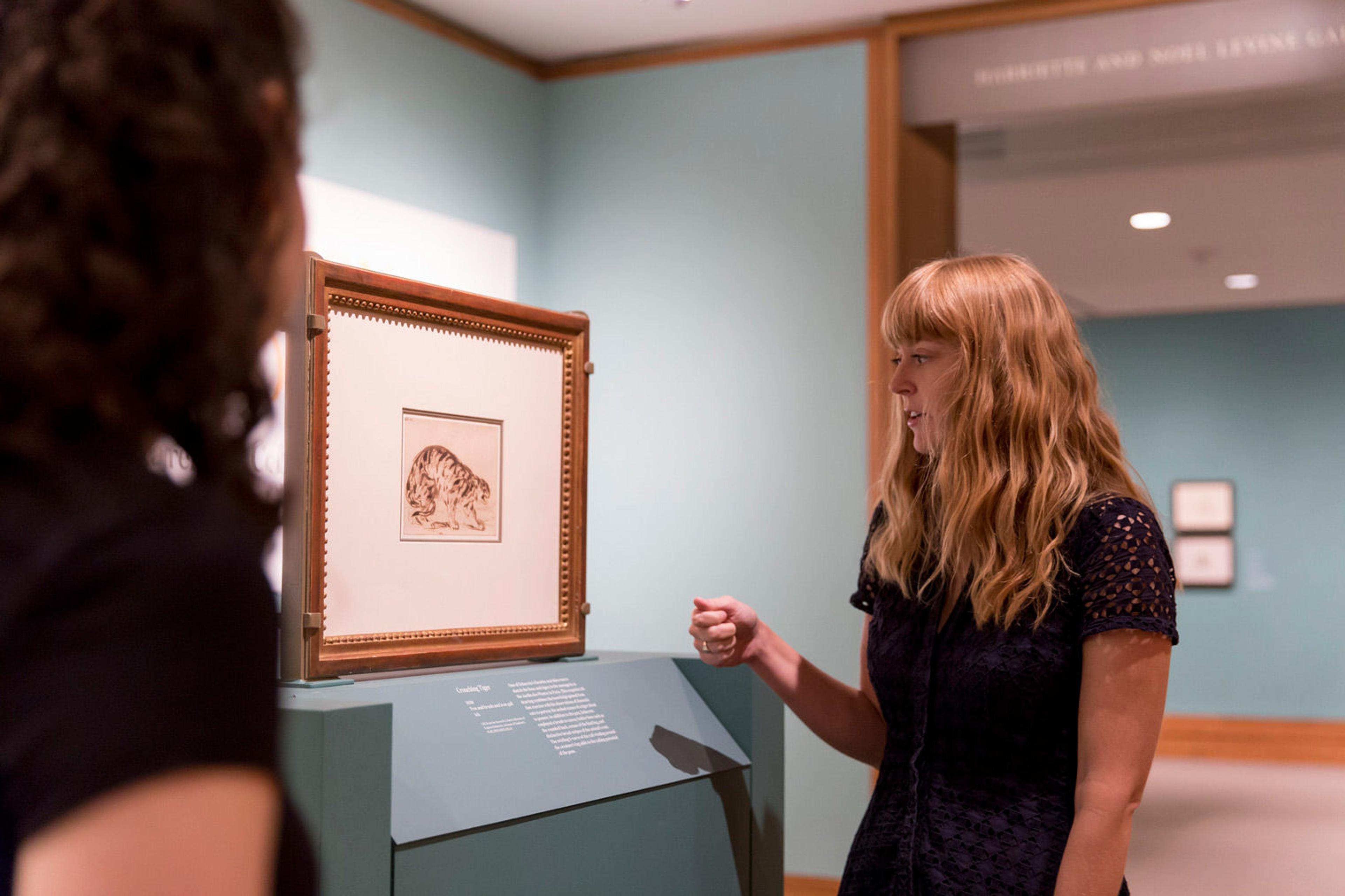 A female curator admires a drawing by Delacroix in a museum gallery
