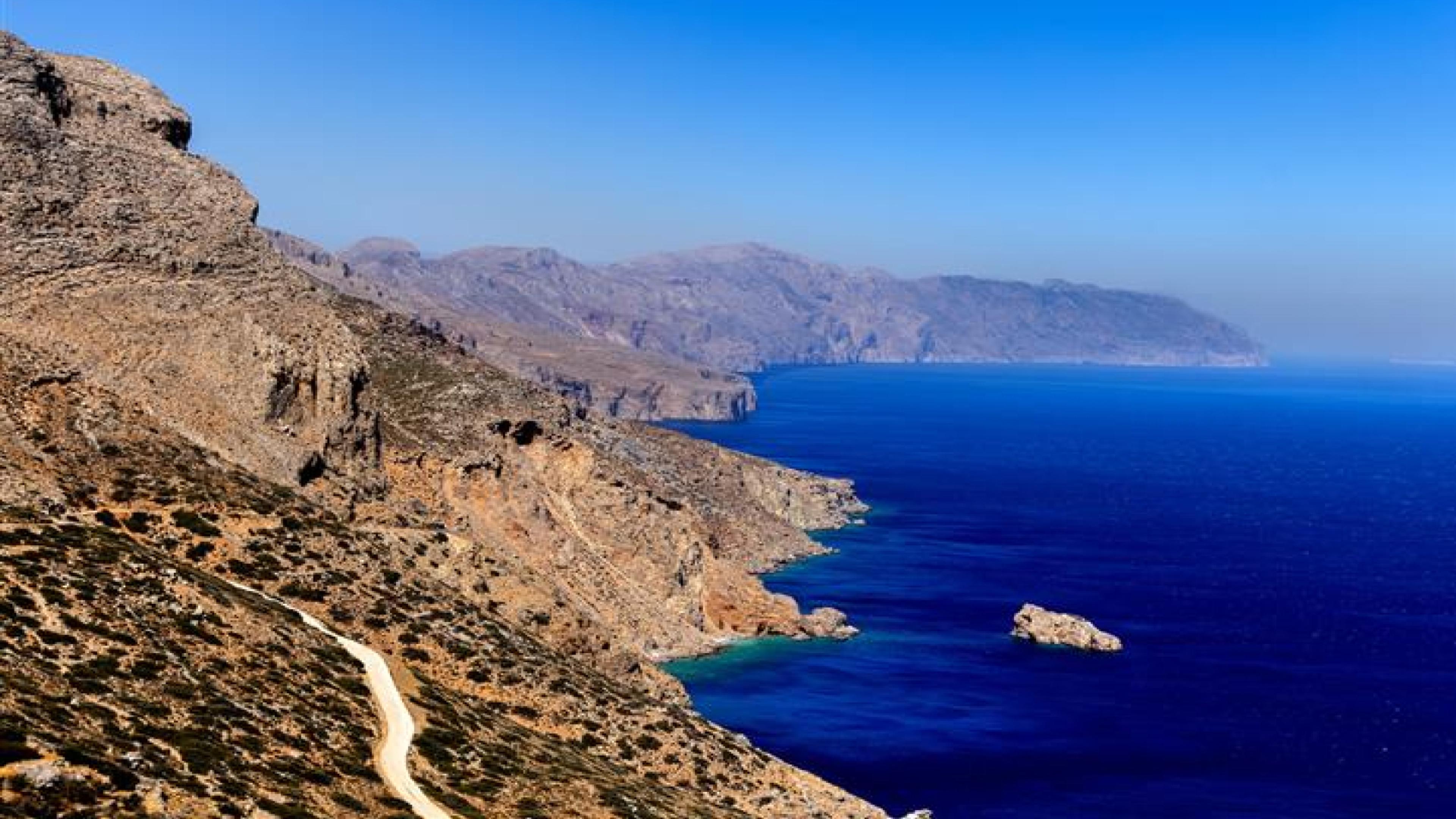 Panoramic view of a picturesque, rocky coastline against a deep blue sea.