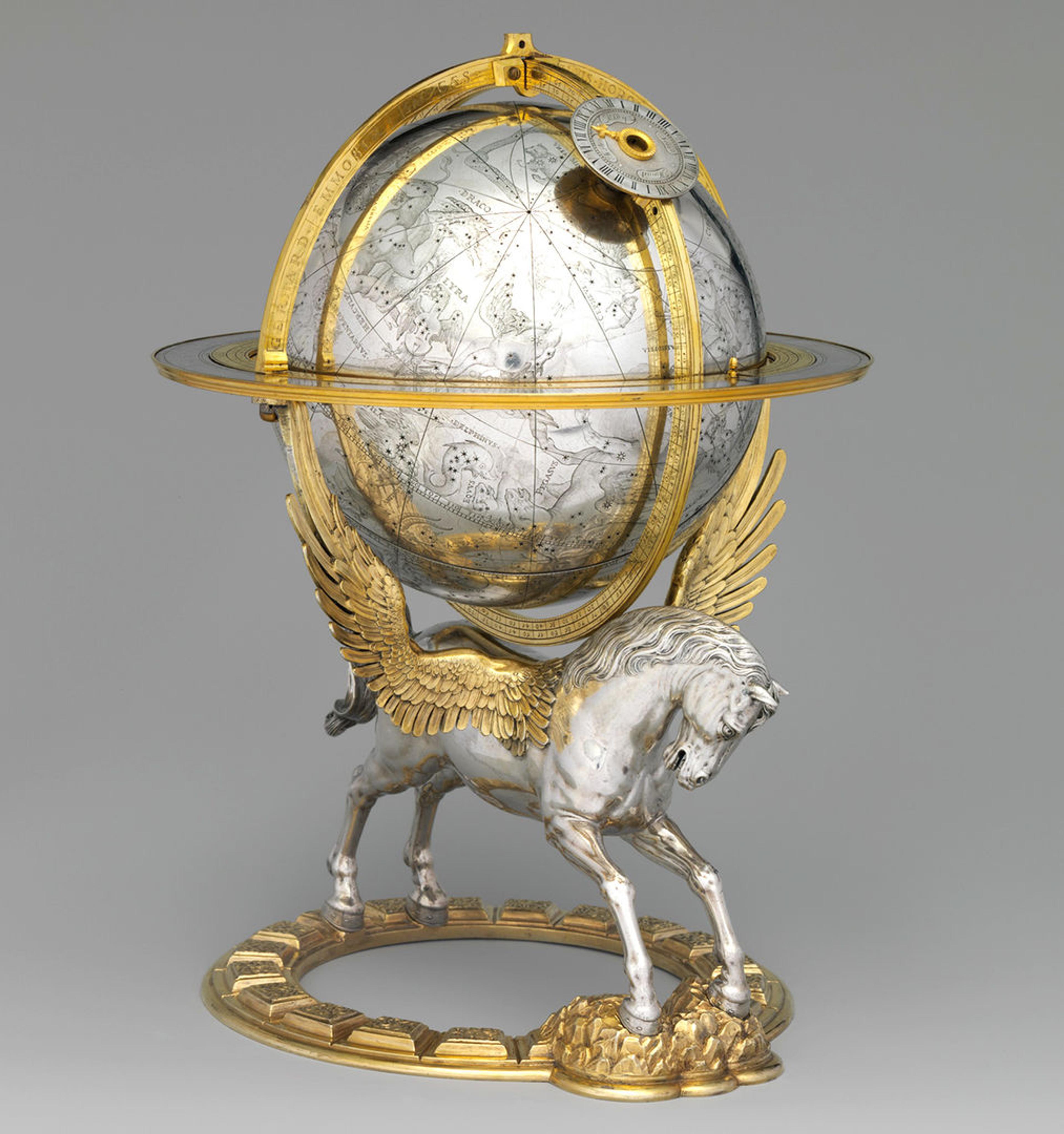 An ornate, silver globe depicting astrological signs, mounted on top of a silver pegusis with golden wings