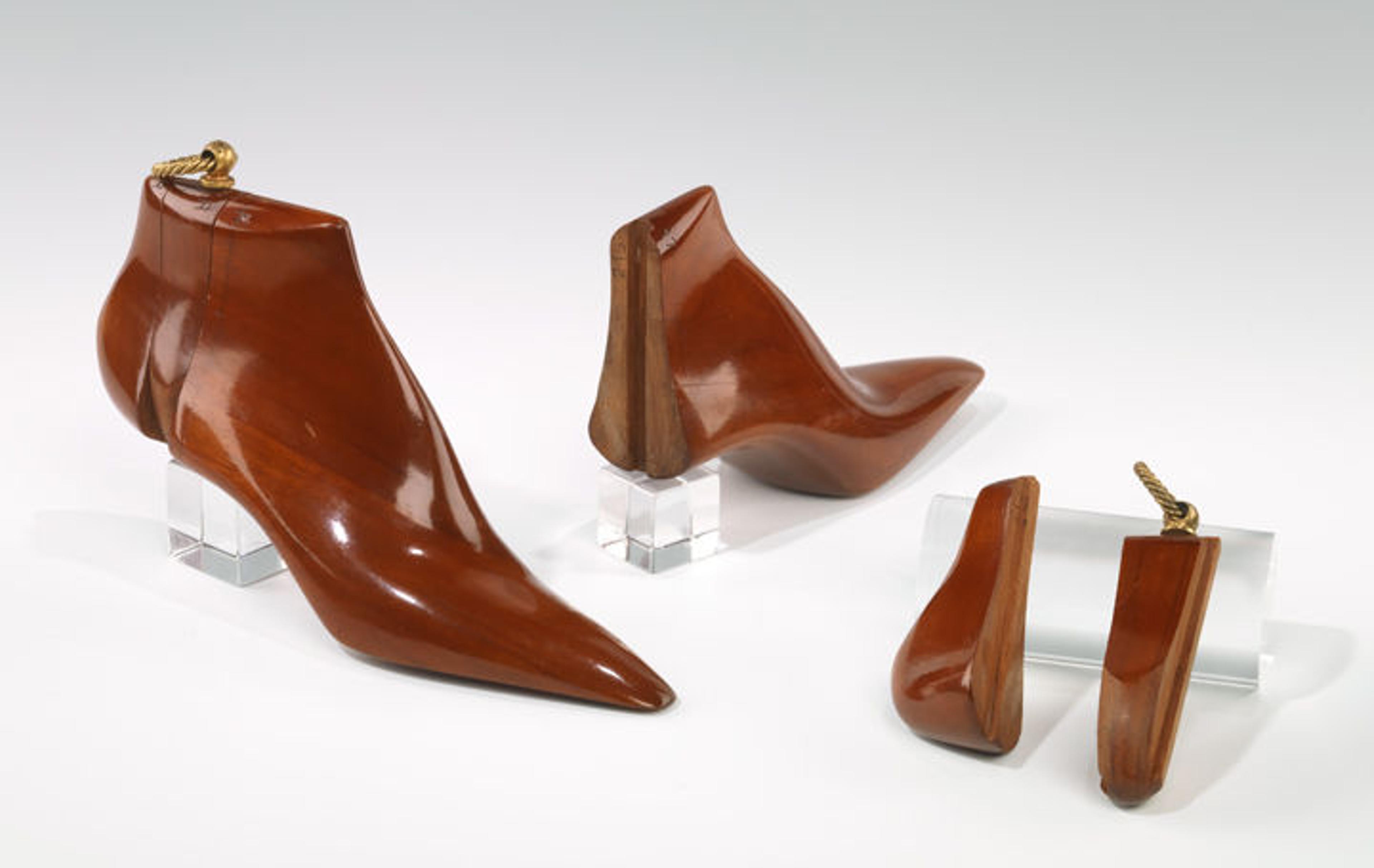 Shiny brown wooden shoe trees on clear blocks