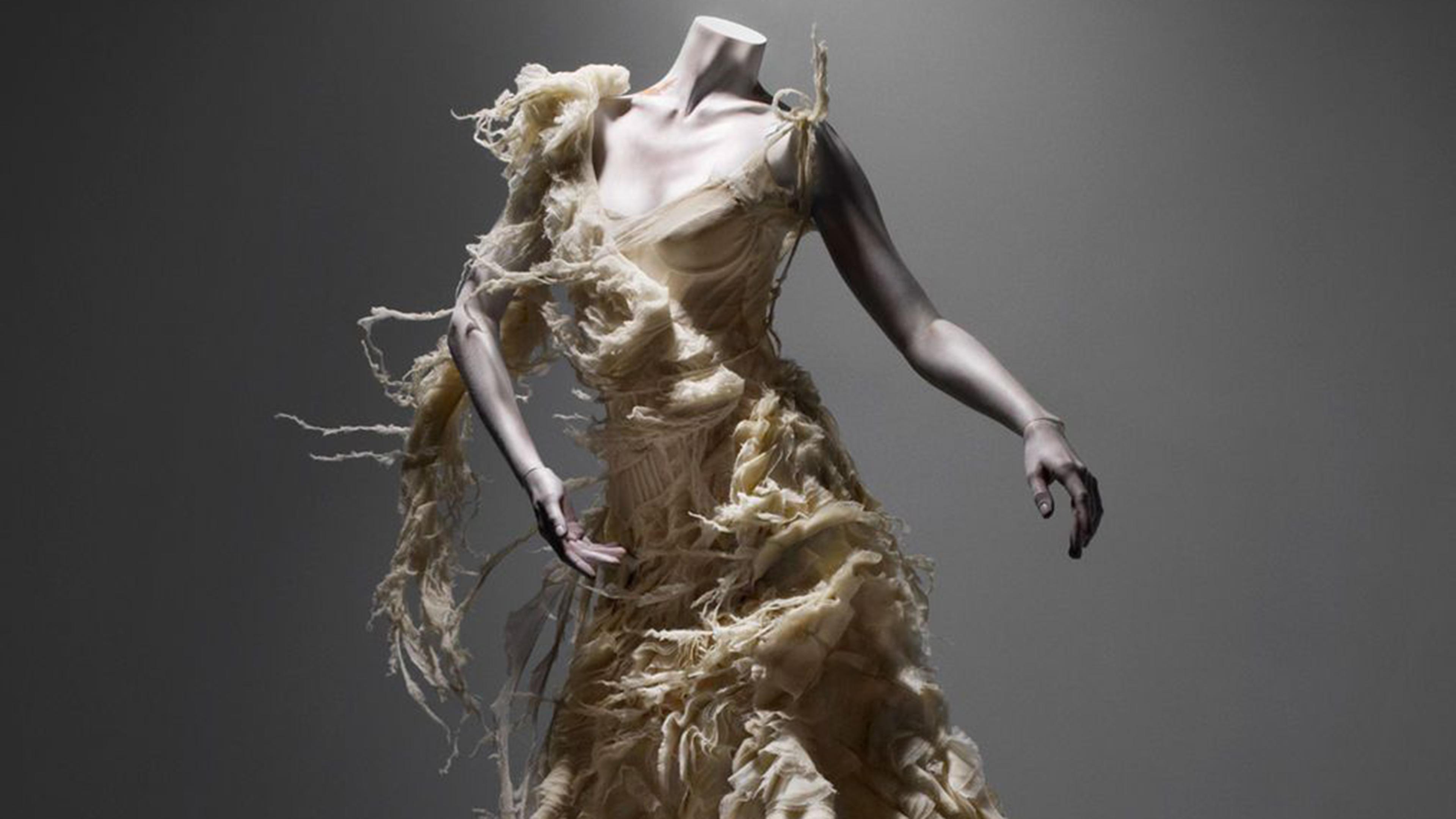 A couture gown by Alexander McQueen against a dark grey background