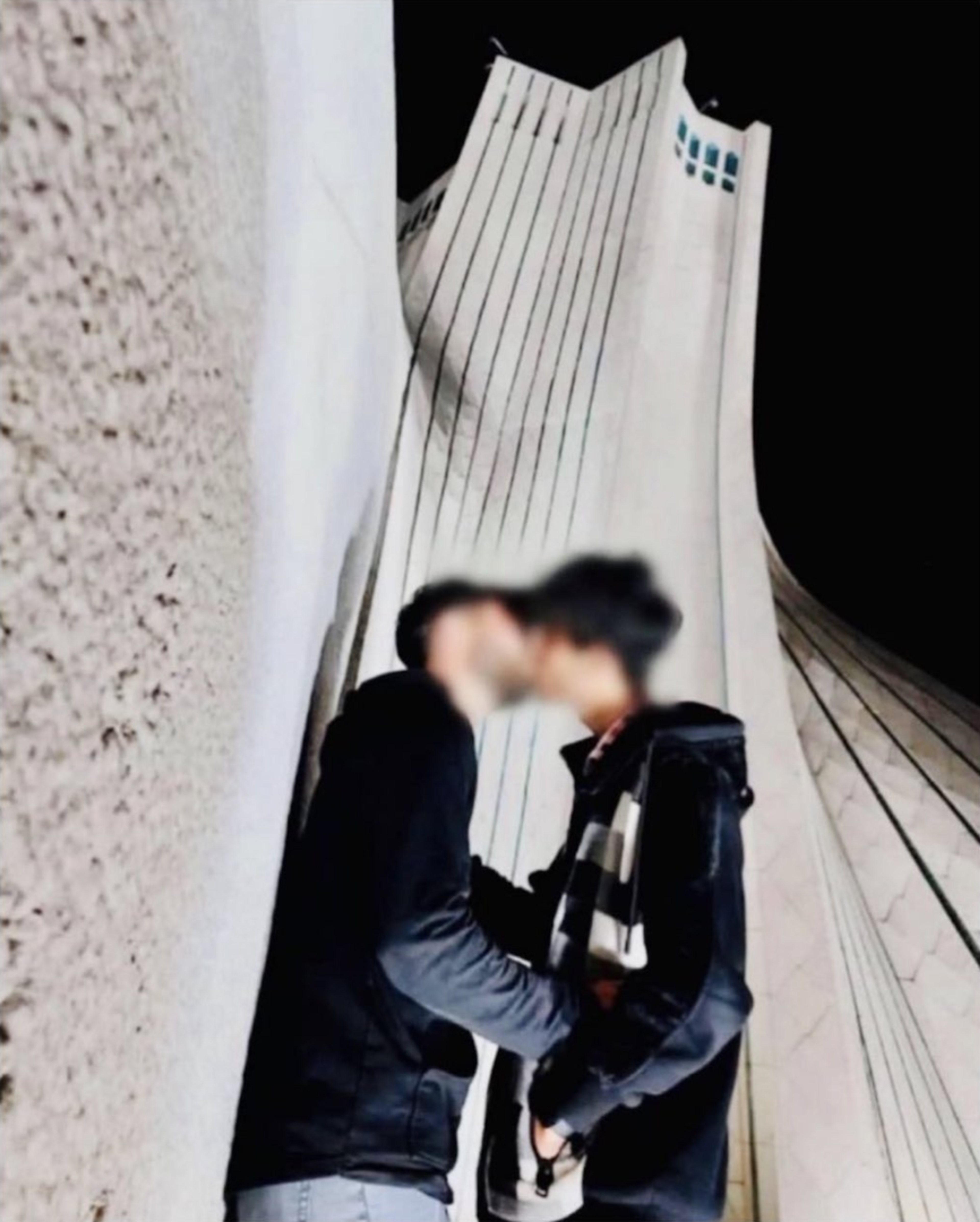 Two men kissing.