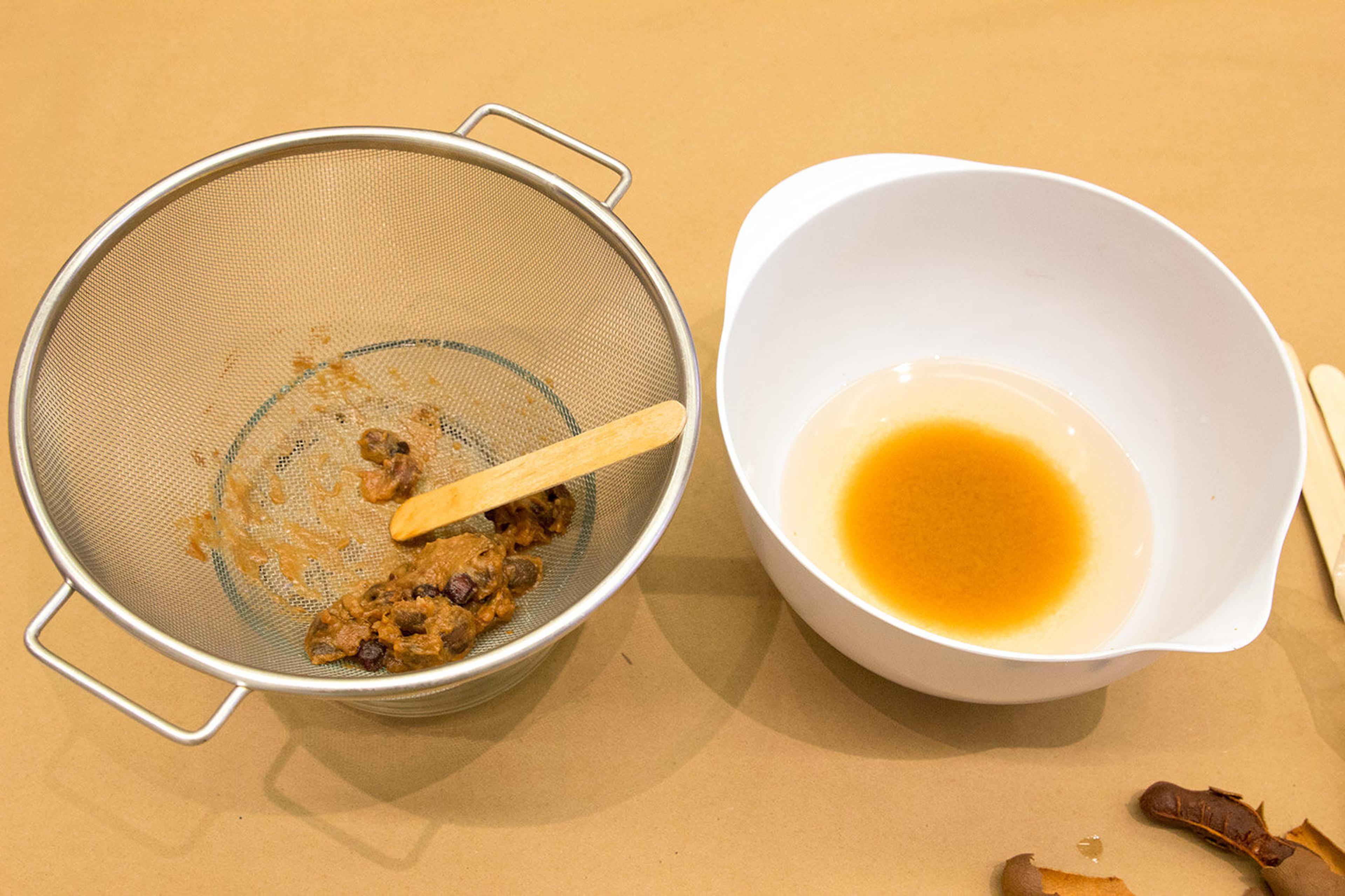 A close up of tamarind paste strained to make orange dye.