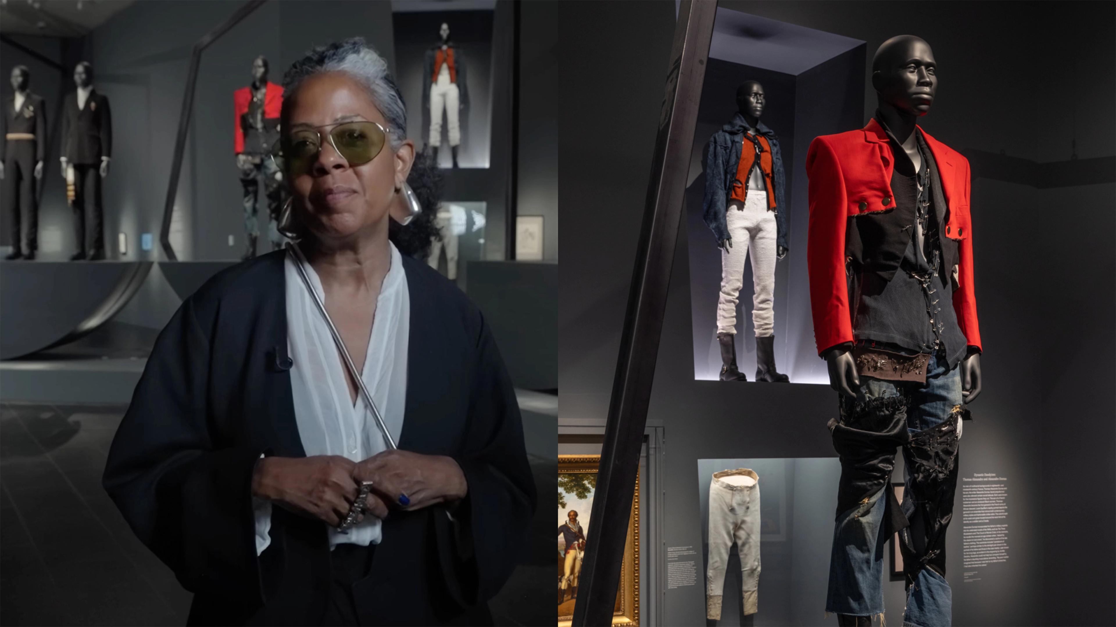 A woman with gray hair and sunglasses stands in a fashion exhibit, wearing a black-and-white outfit. Mannequins display avant-garde clothing designs.