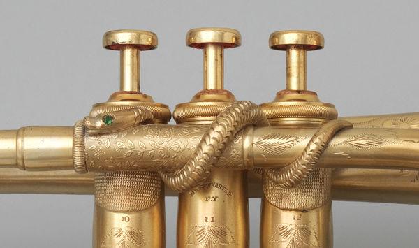 Detail view of the jewel-eyed serpent wrapped around the cornet's valves, a popular embellishment of nineteenth-century German brass instruments