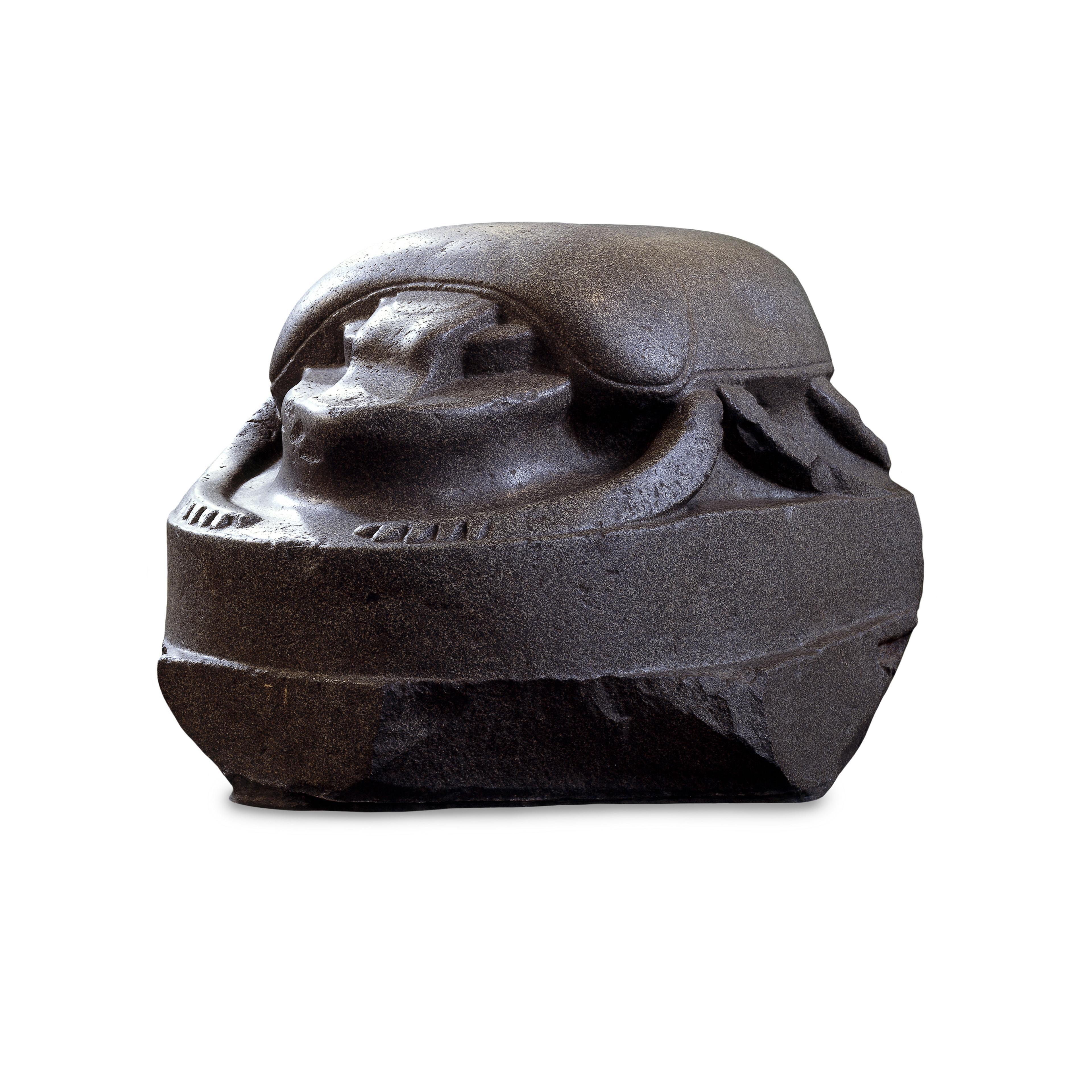 Monumental stone sculpture of a scarab beetle. It has a smooth, rounded shape.