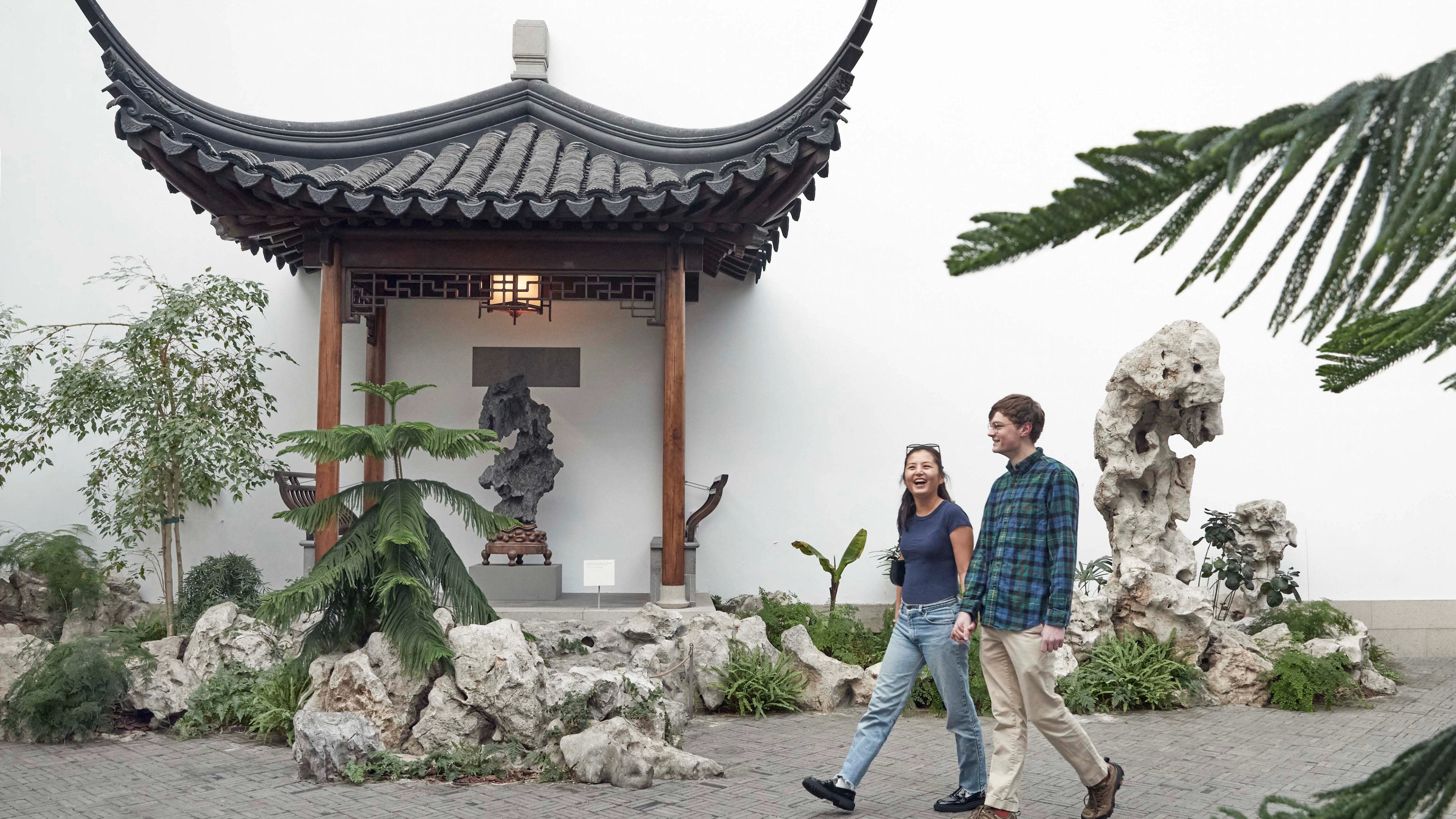 Two people walking through The Astor Chinese Garden Court at The Met. 