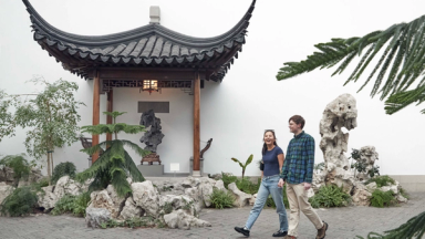 Two people walking through The Astor Chinese Garden Court at The Met.