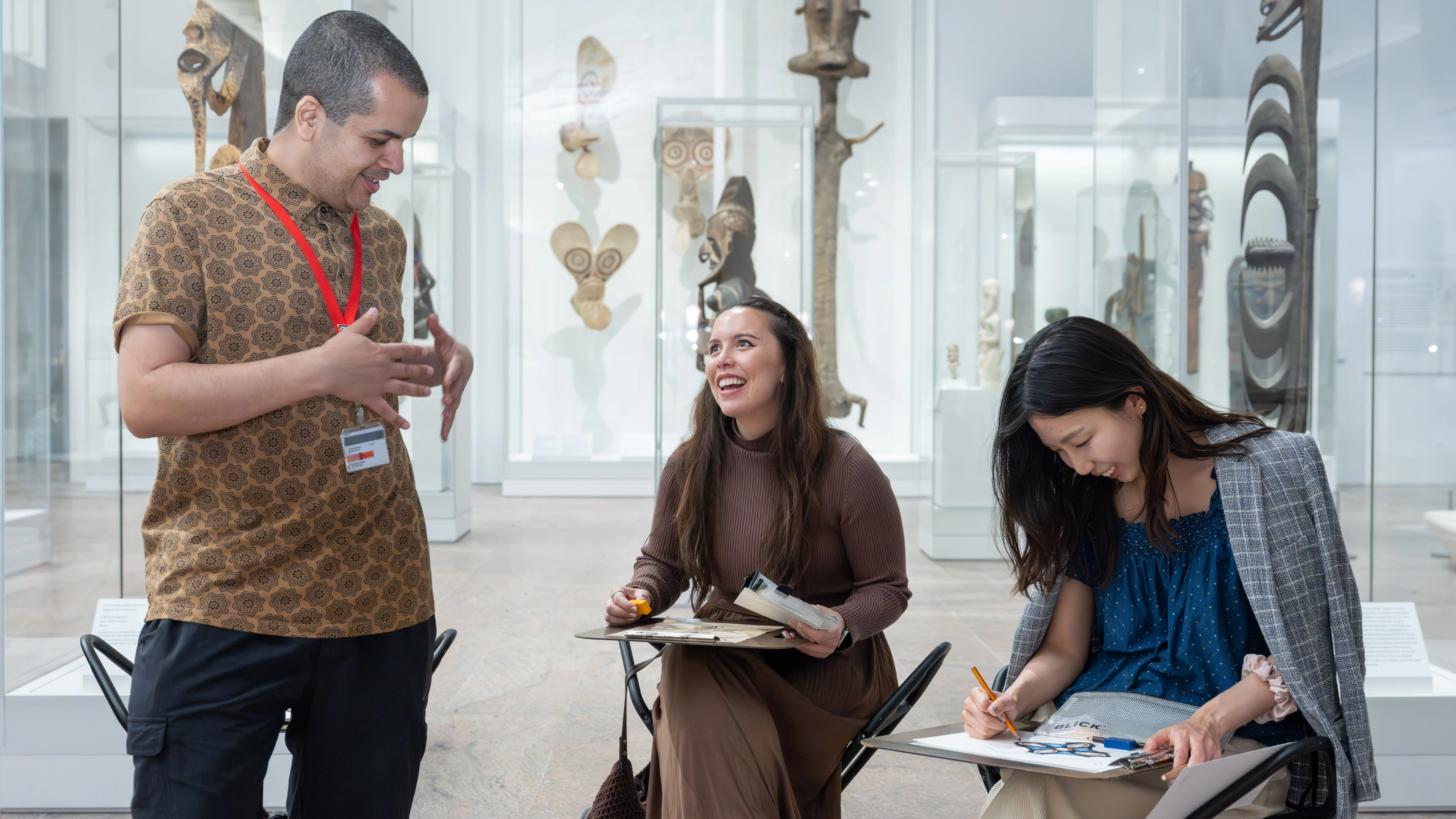 A group of people making art and chatting in The Michael C. Rockefeller Wing. 