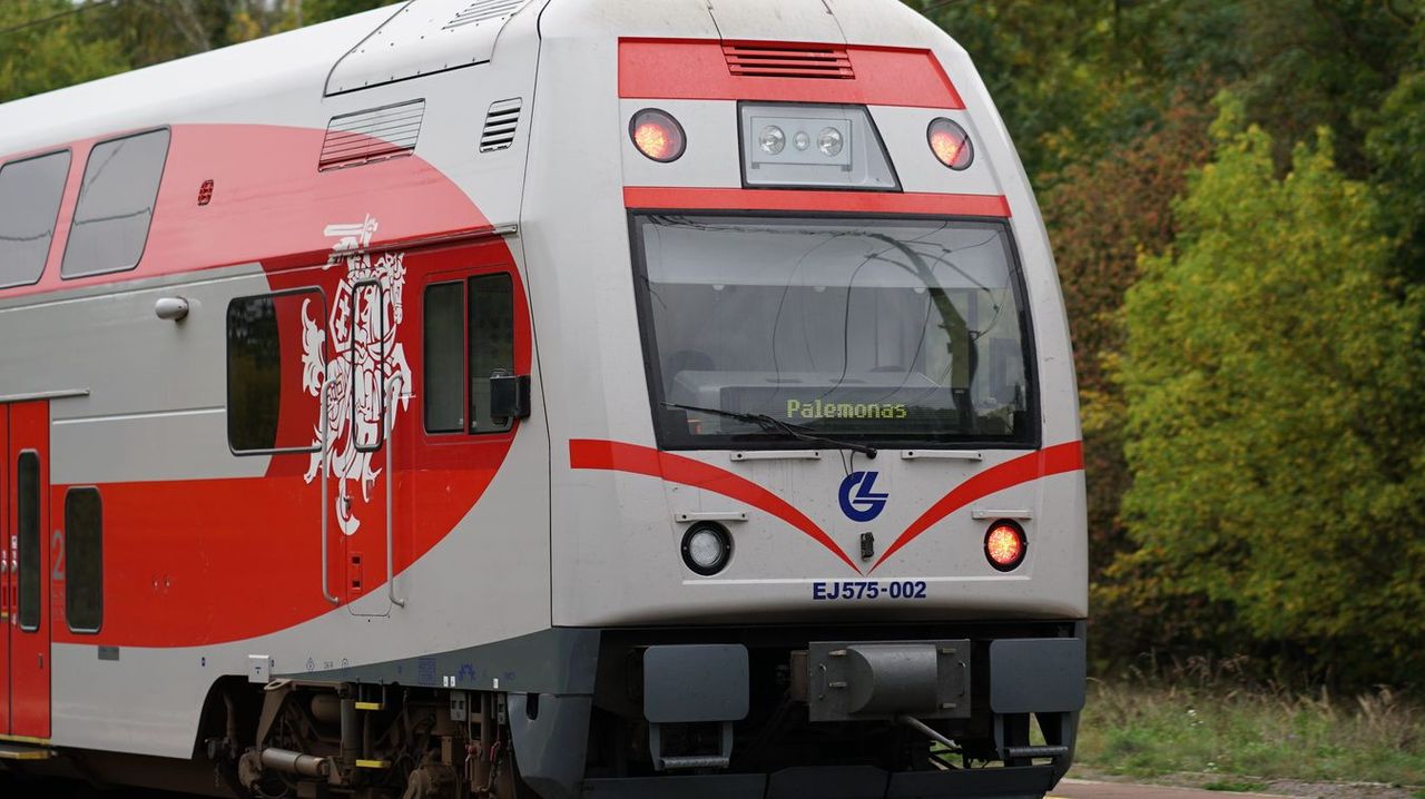 A modern Lithuanian train traveling through the countryside, captured in detail.