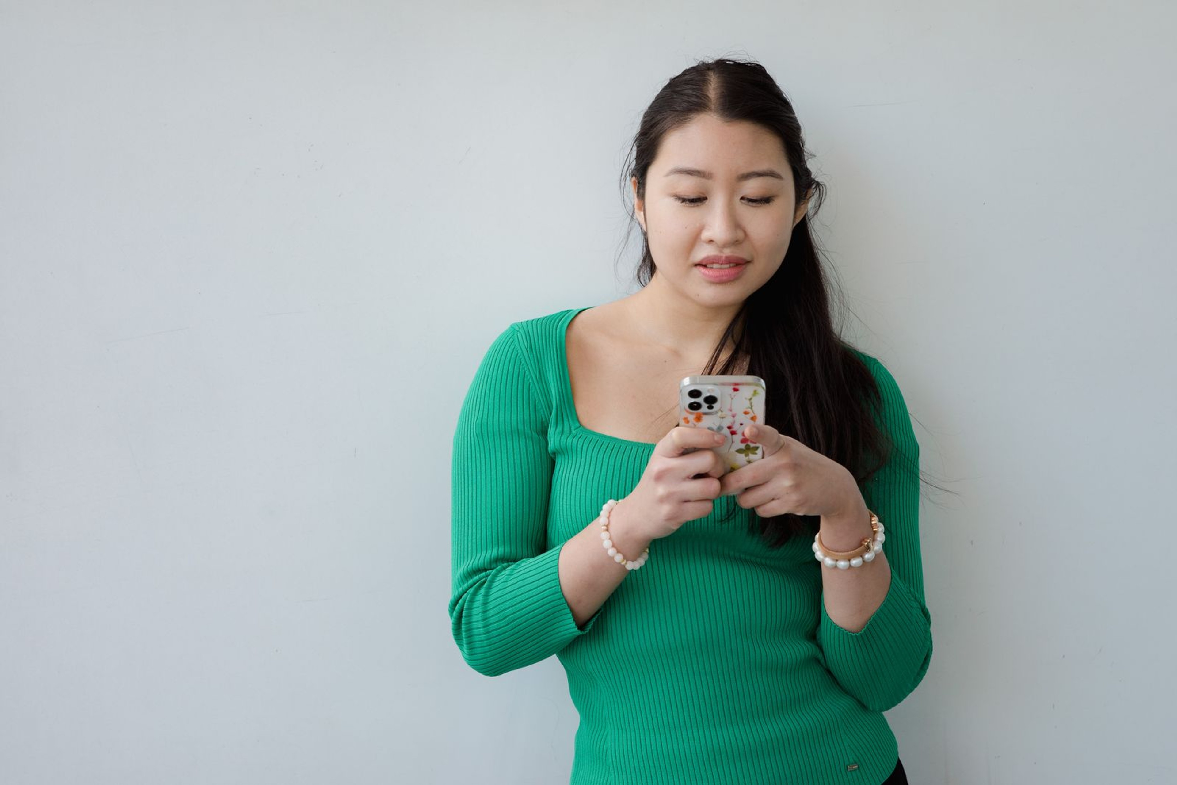 Young Cambodian woman typing a message on her smartphone