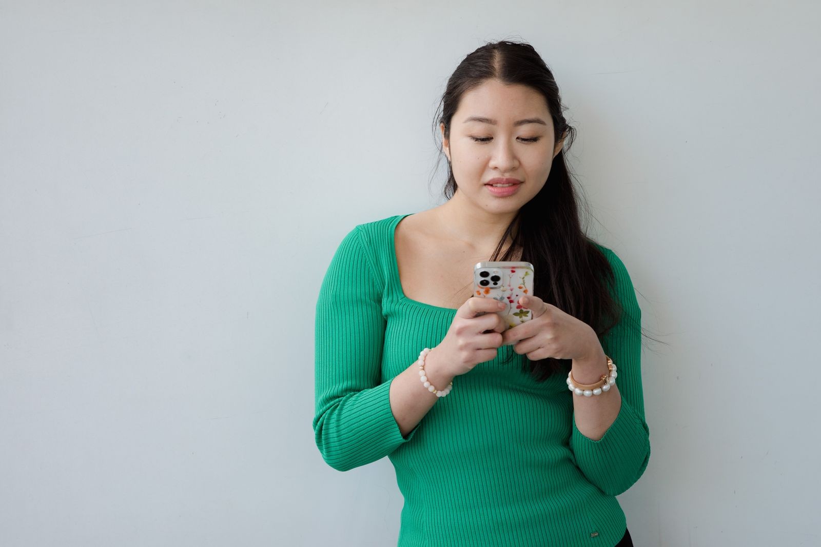 Young Cambodian woman typing a message on her smartphone