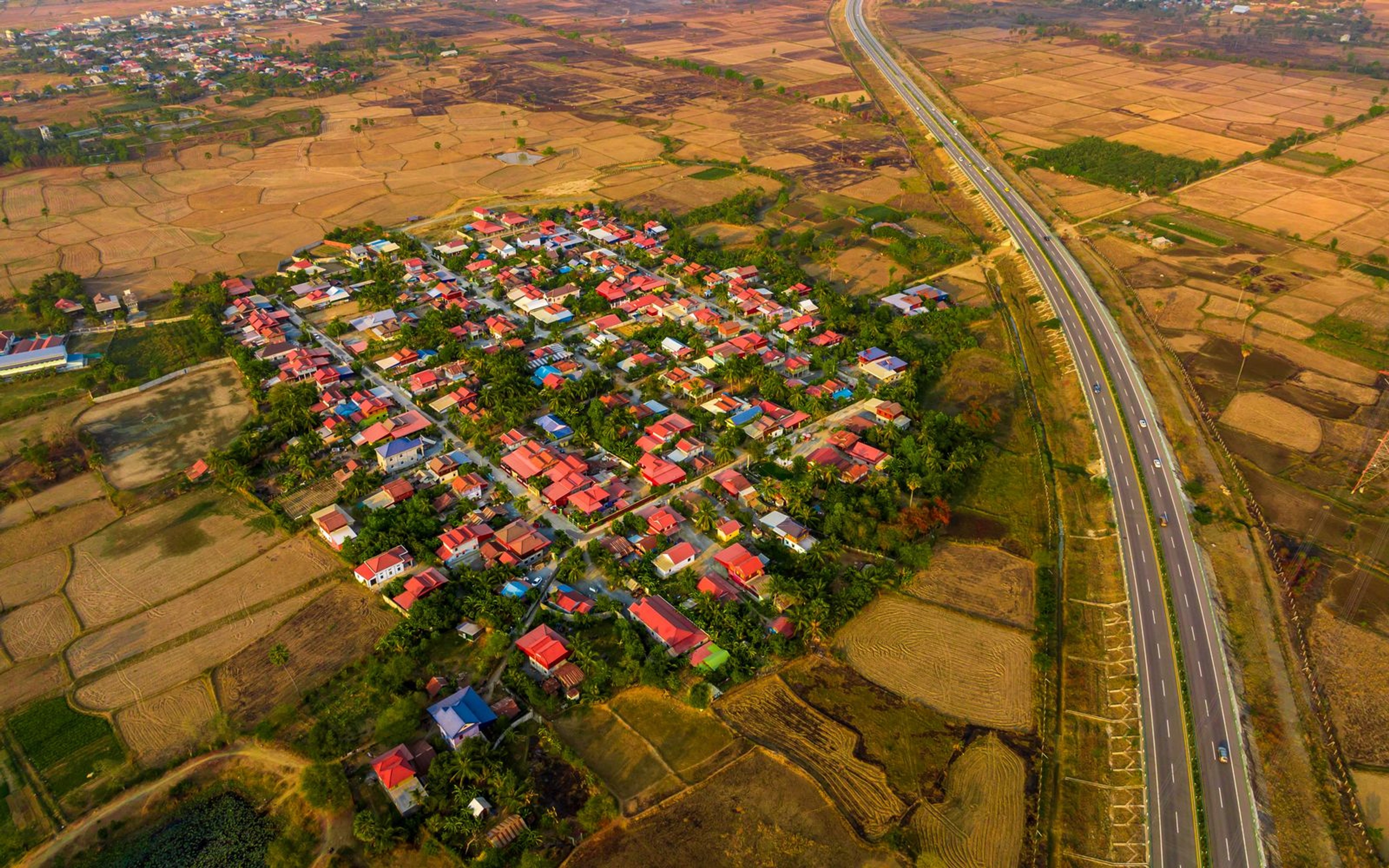 Aerial view of a rural Cambodian town surrounded by rice fields