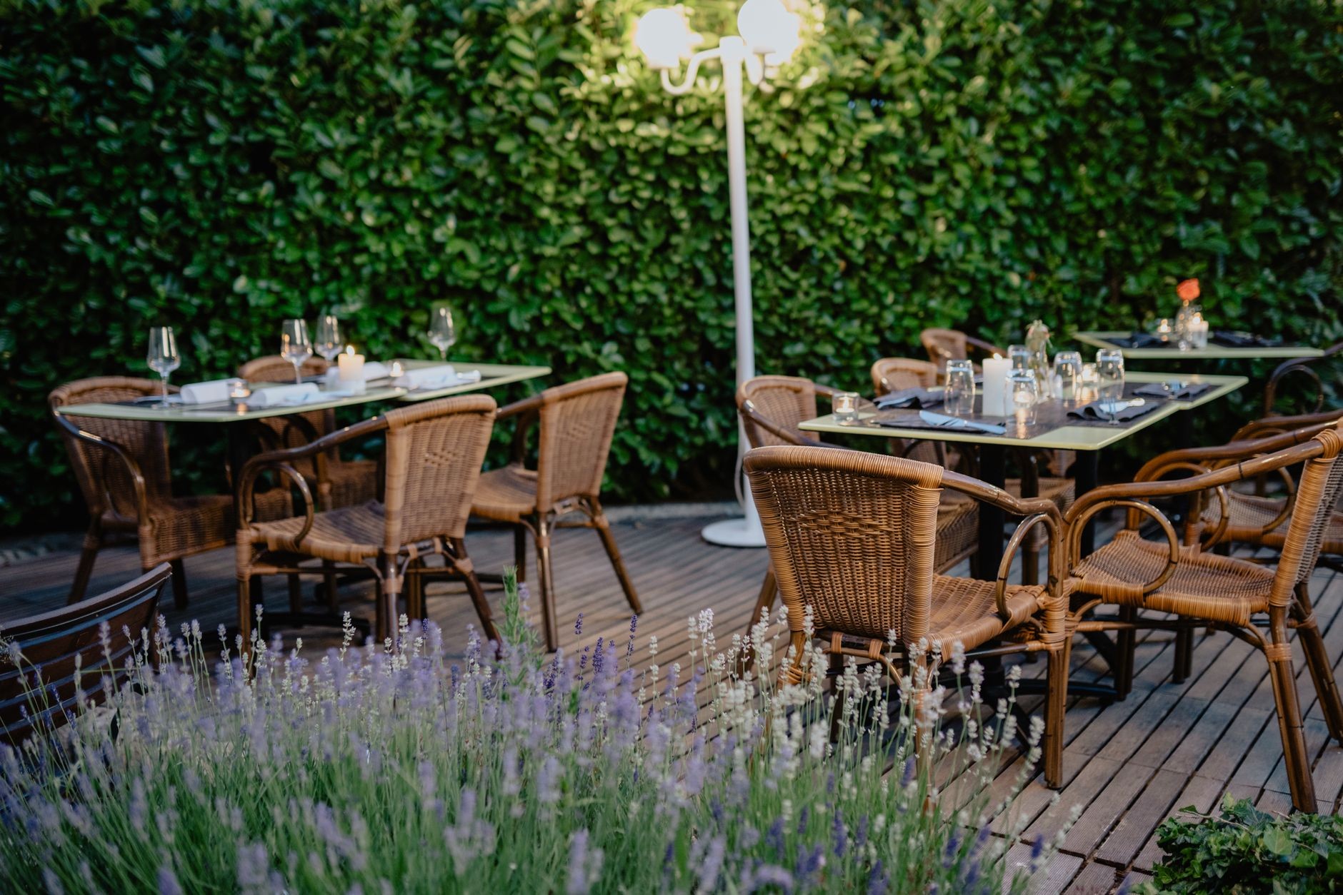 Empty tables set on a garden restaurant terrace at dusk
