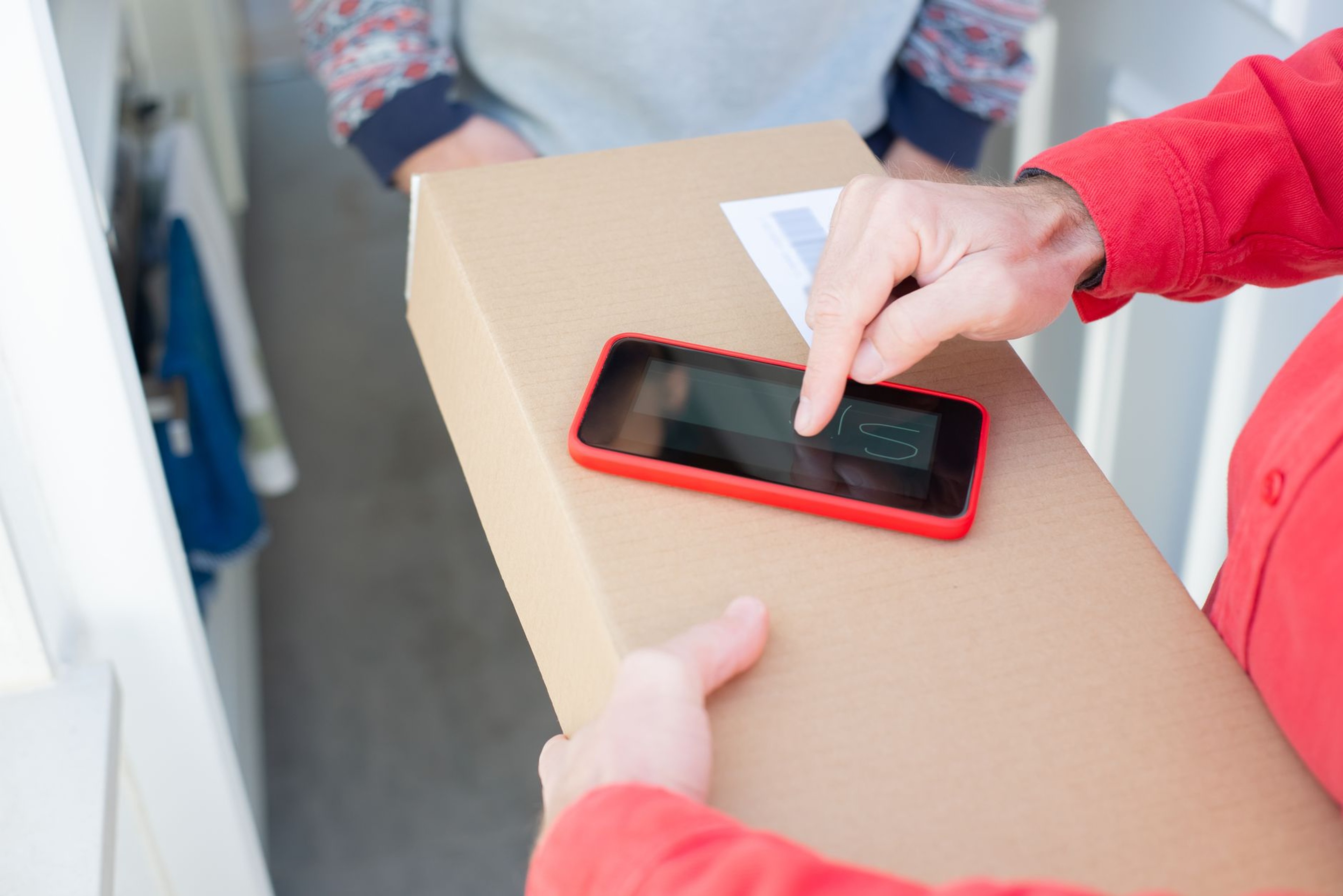 Delivery courier confirming a parcel handoff on a smartphone