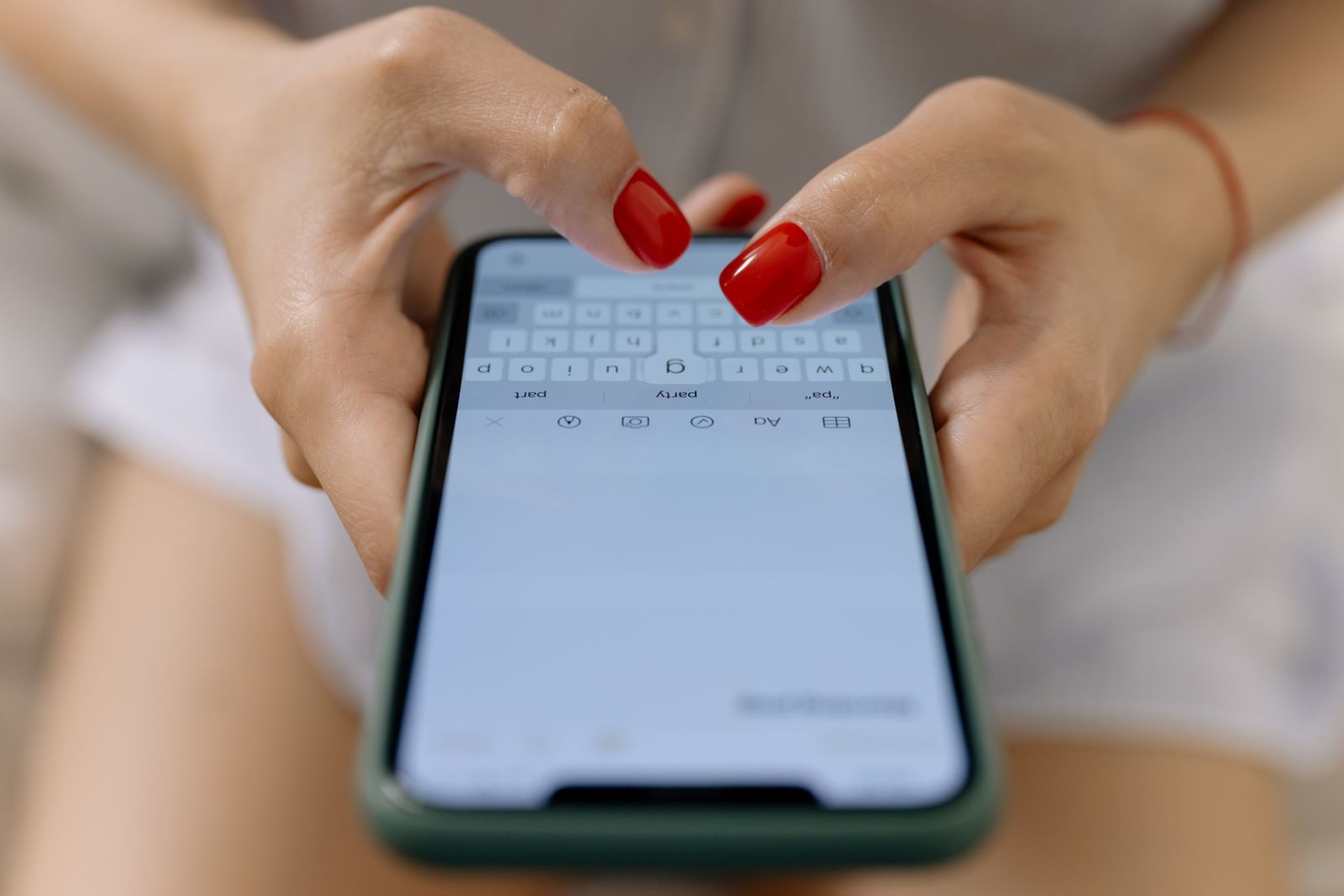 Close-up of two hands typing a message on a smartphone
