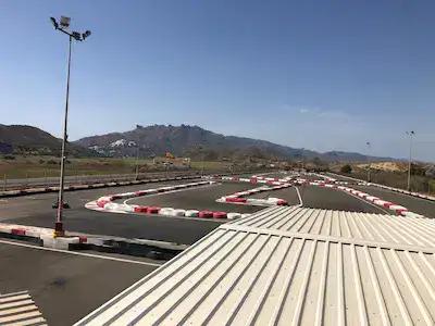 Looking at the Karting Garrucha track from the viewing platform. Hills in the background, ugly flat roof in the foreground.