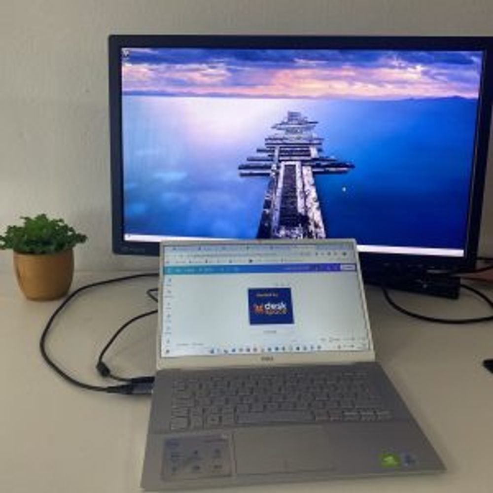 A laptop in the foreground and an external monitor with a different image in the background. DeskSpace shows you how to set it up.
