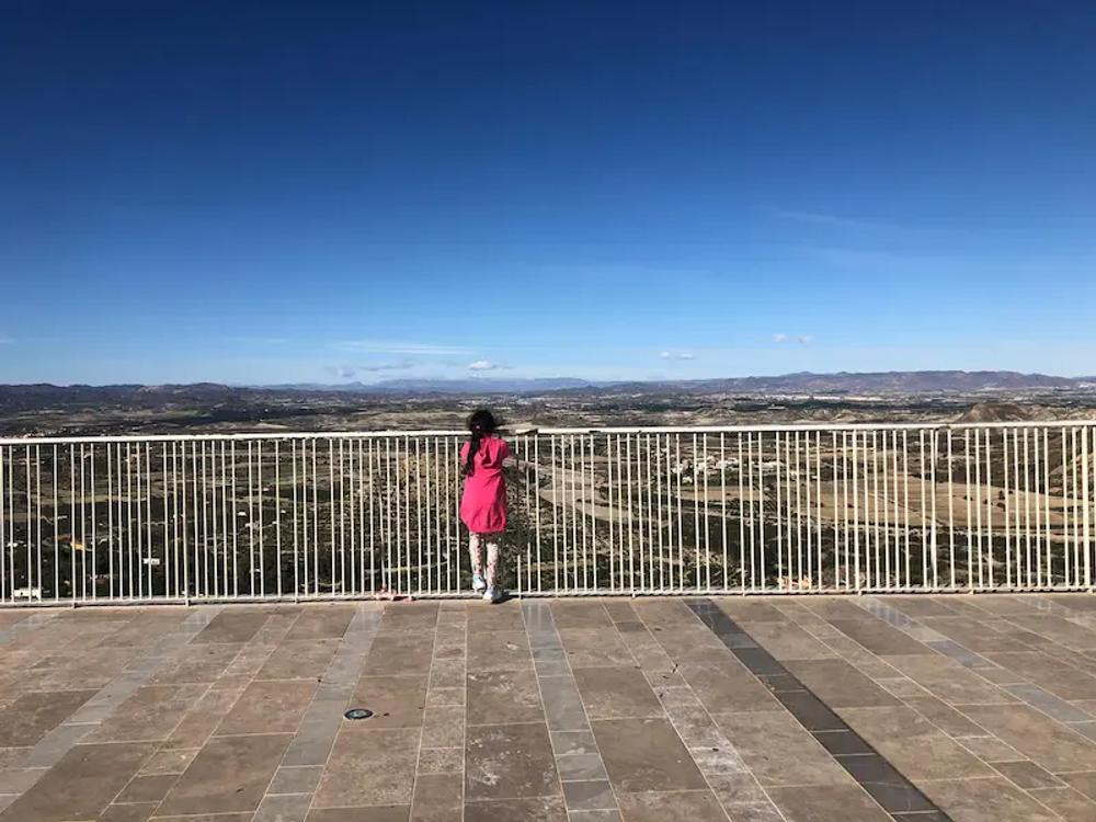 Viewing Point at Mojacar Pueblo - showing a girl in pinking looking over the railings at the landscape beyond.
