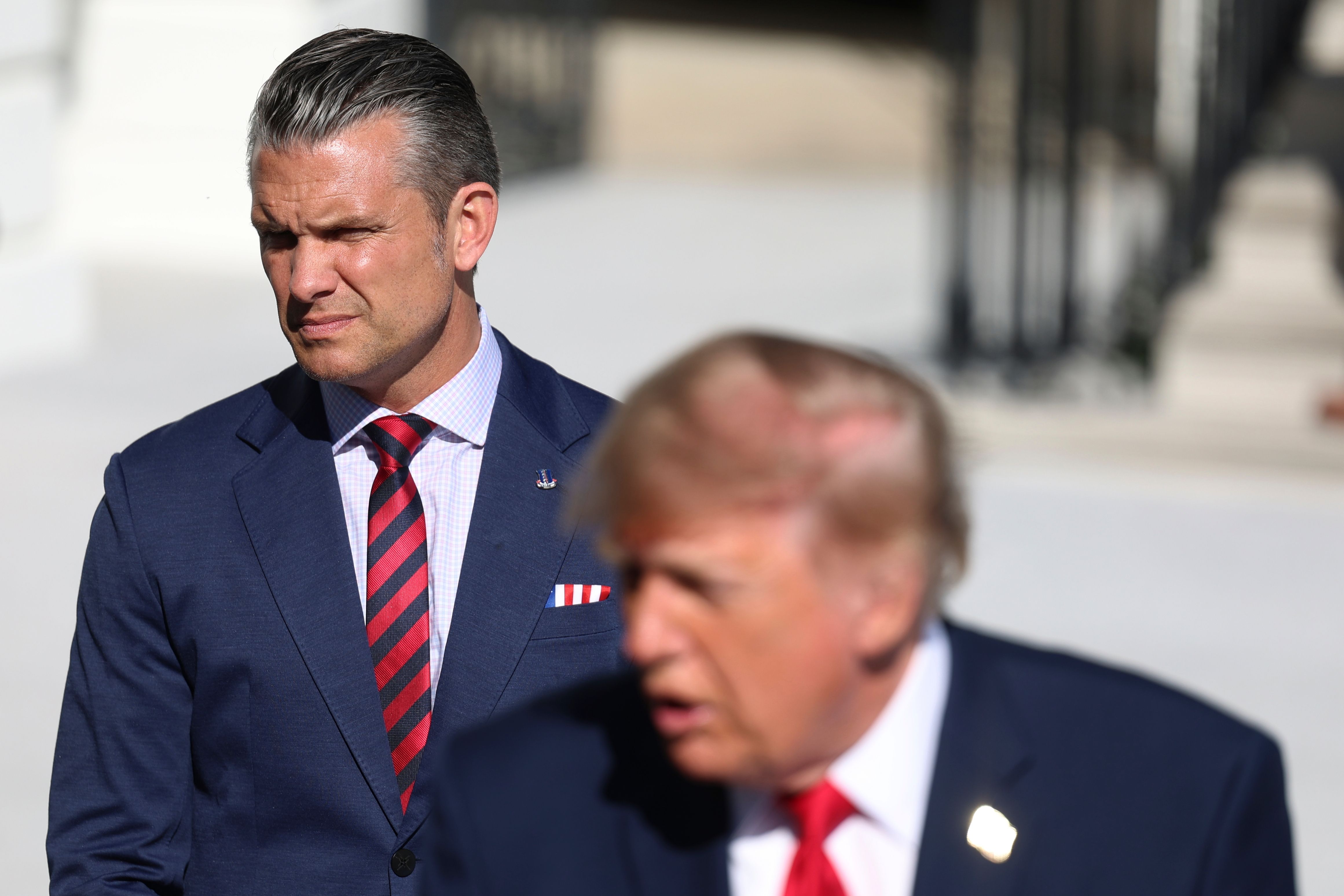 Defense Secretary Pete Hegseth listens as President Donald Trump speaks with reporters before departing on Marine One from the South Lawn of the White House, Tuesday, Oct. 6, 2026, in Washington. (AP Photo/Tom Brenner)