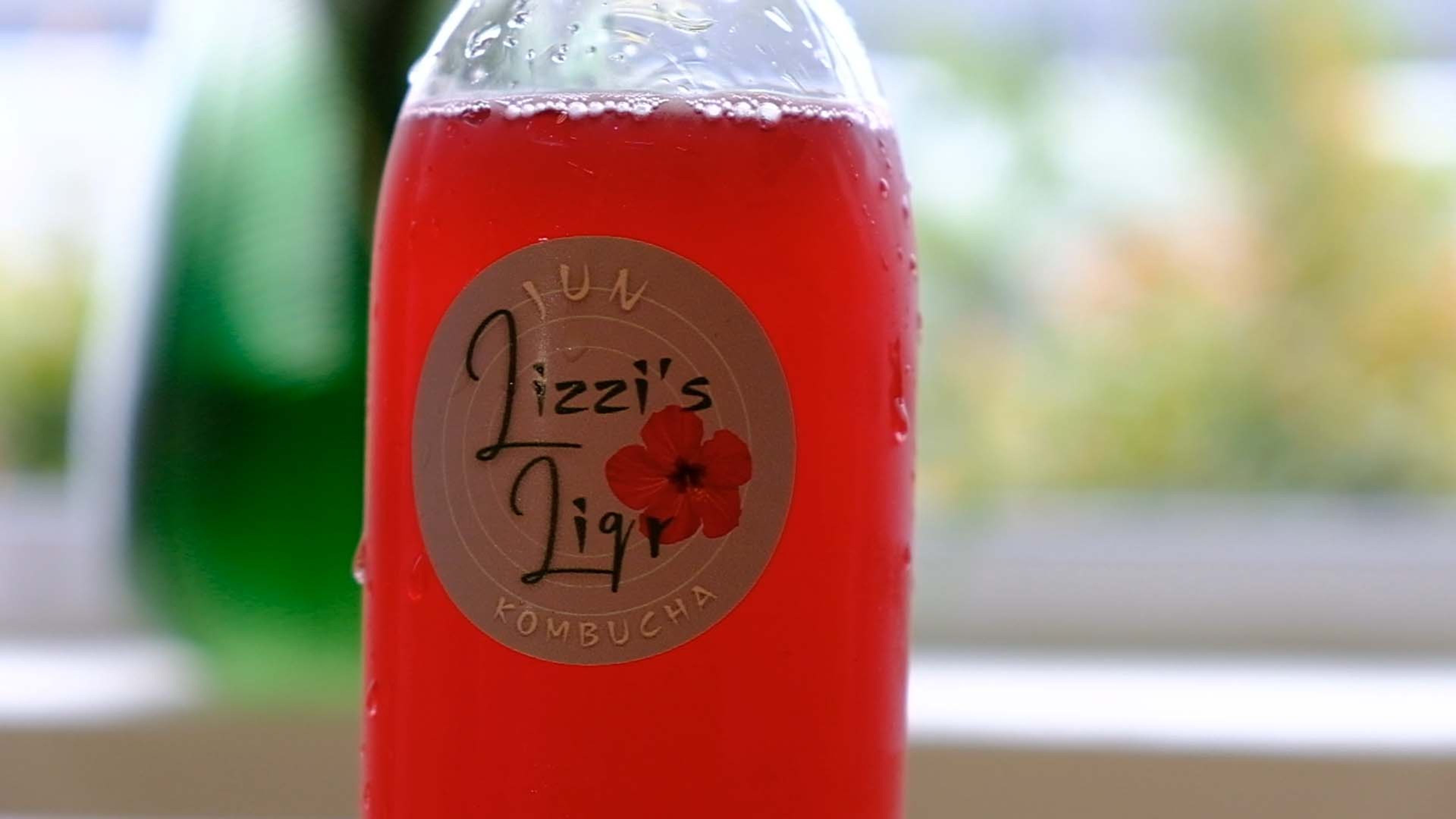 Close-up of a red bottled drink with a hibiscus-flower label