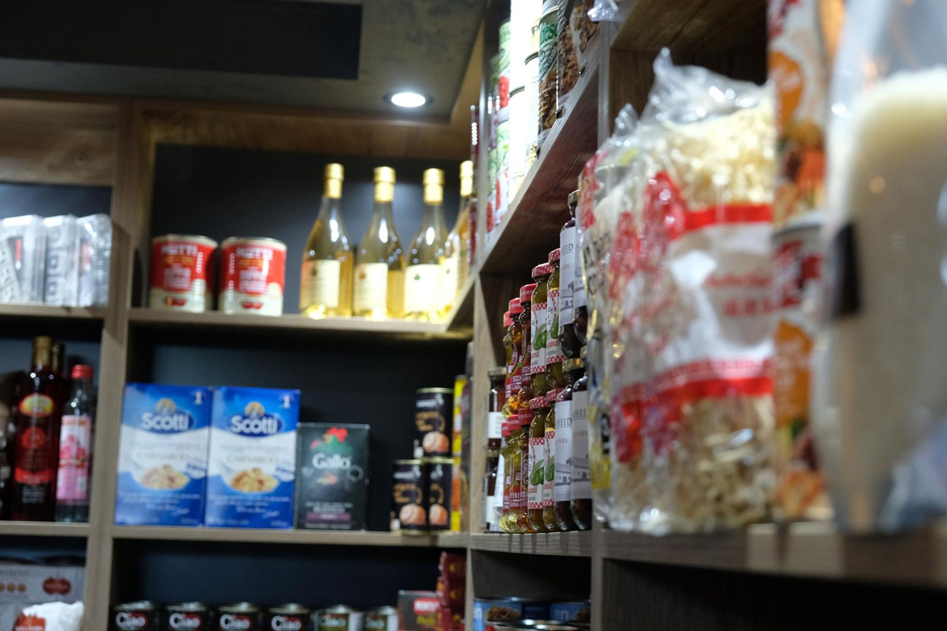 Shelves of sauces, rice and noodles with warm spotlights above