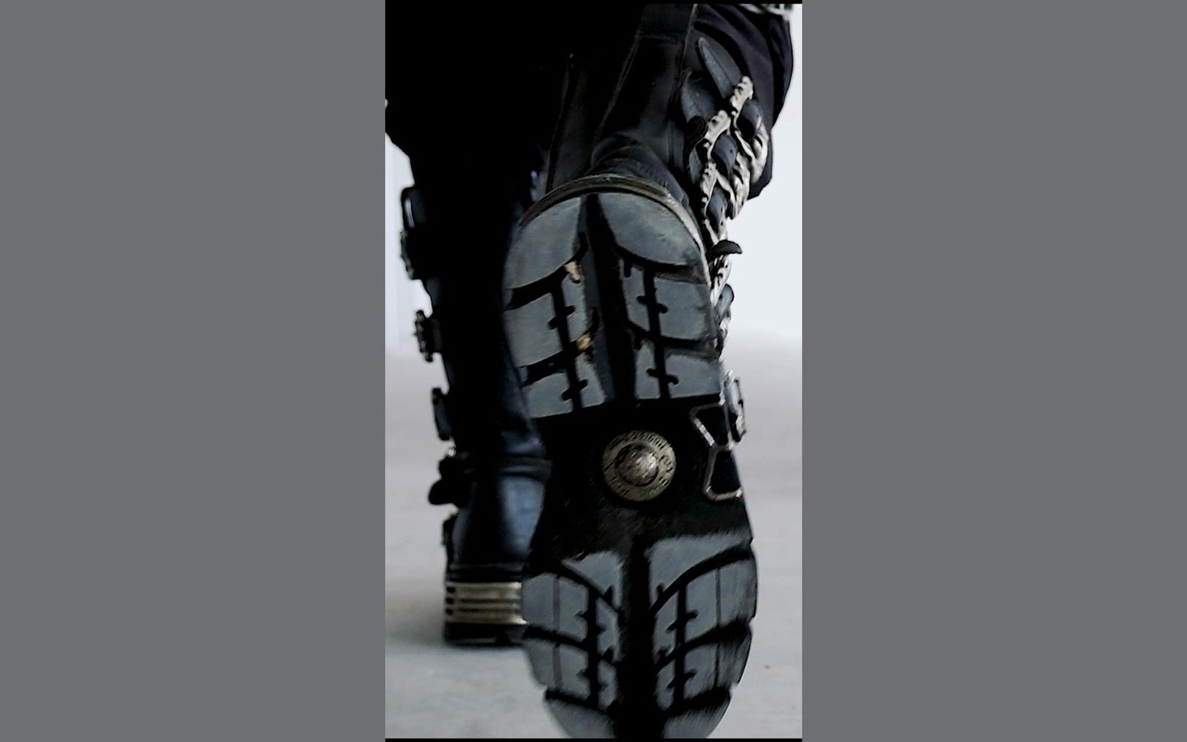 New Rock boot sole lifted toward the camera showing a round emblem and deep tread