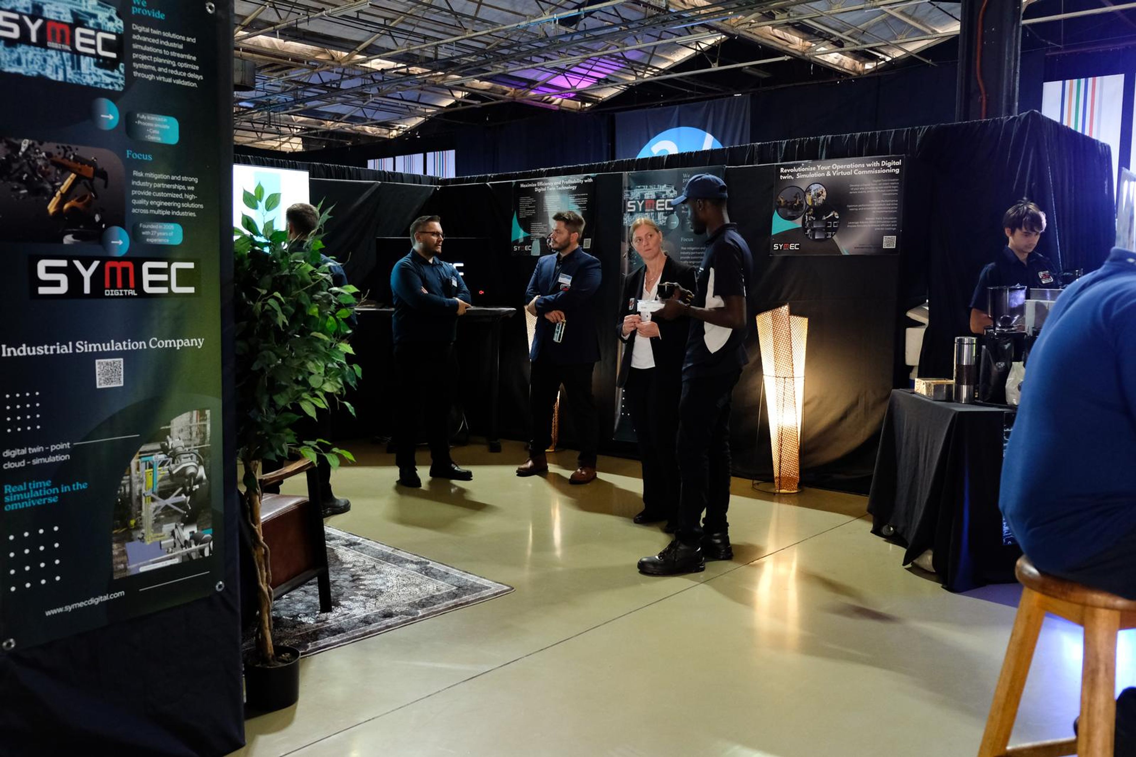 Wide view of the Symec stall with visitors and the team