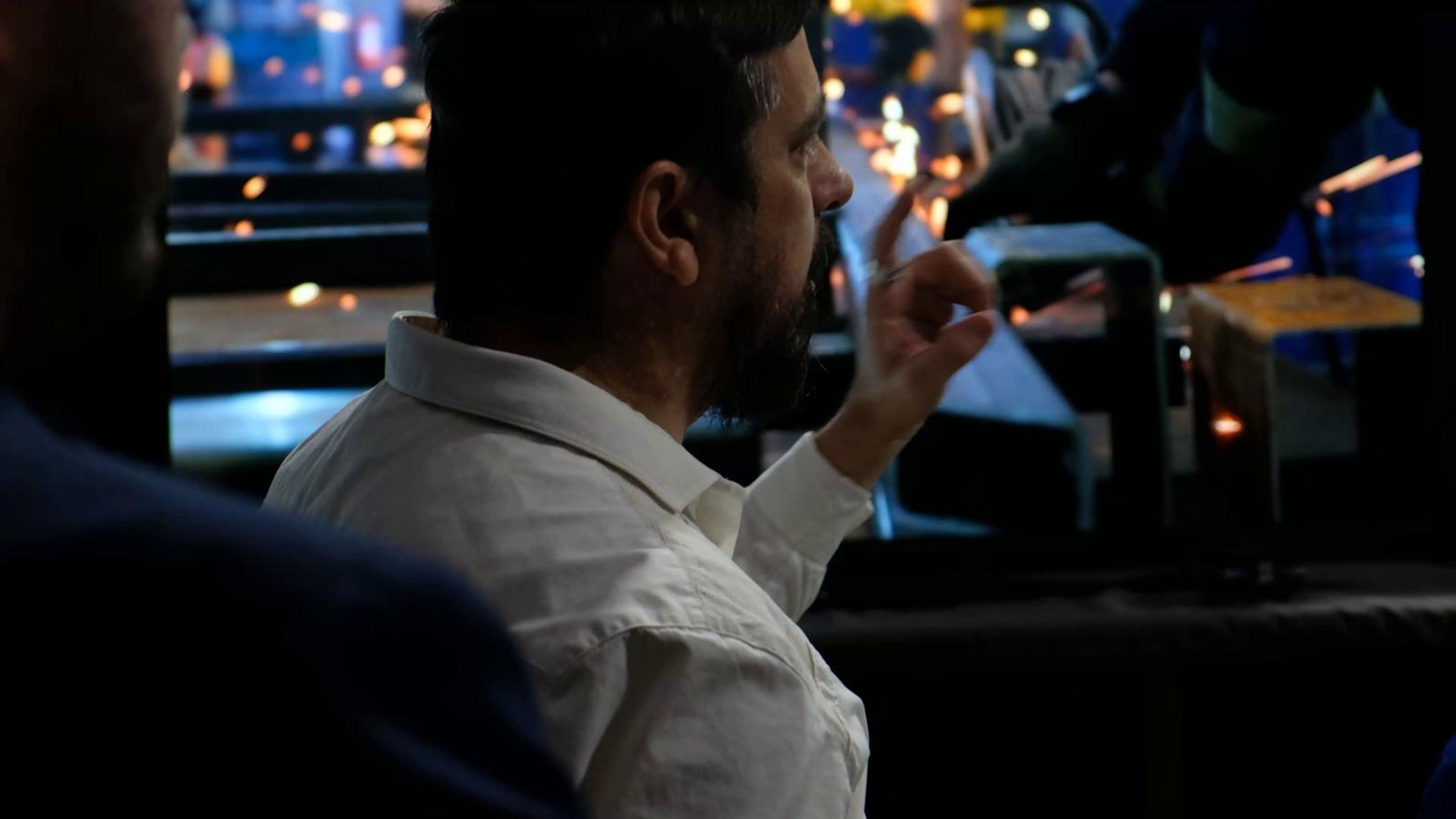 Presenter in a white shirt gesturing at a screen