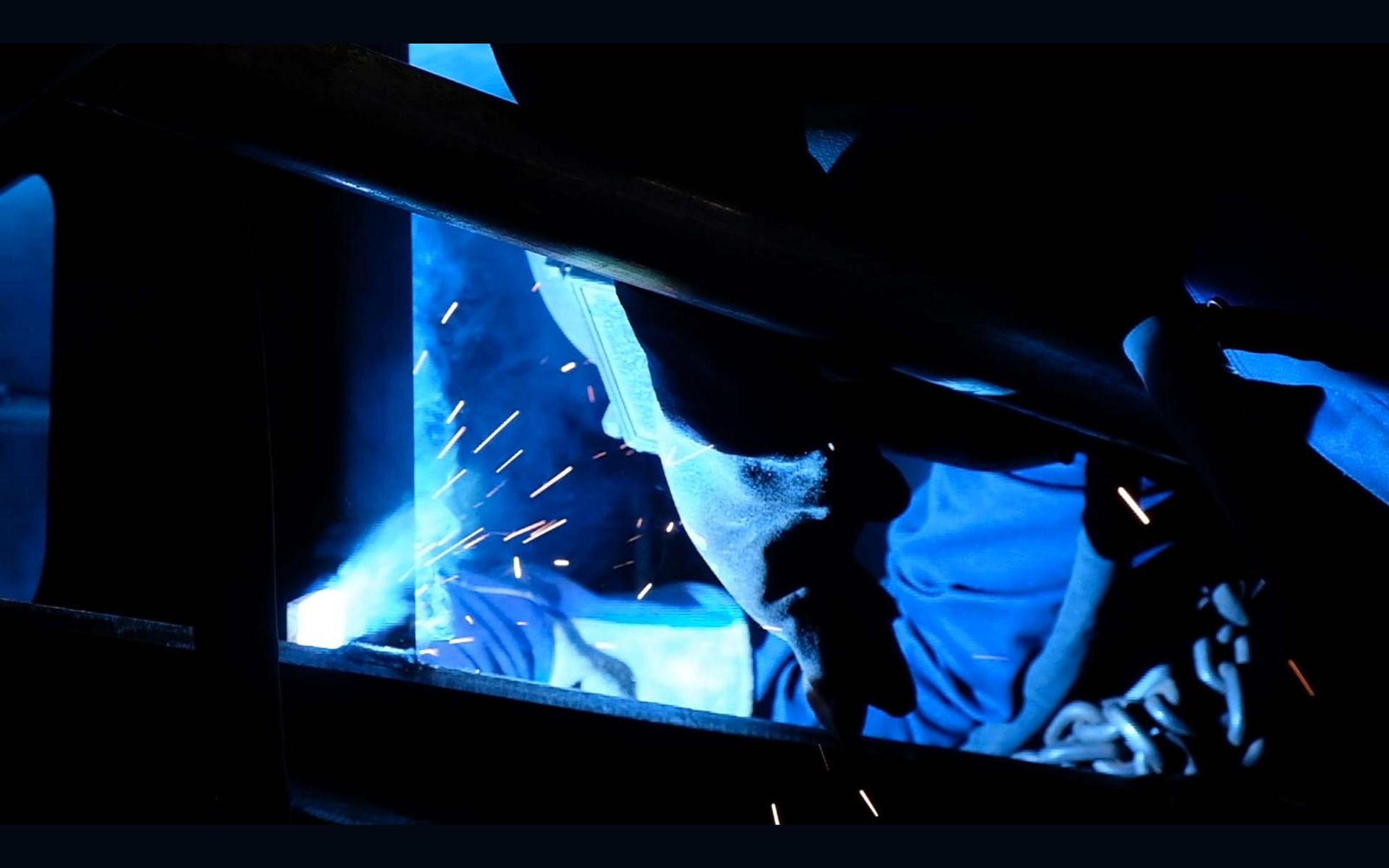 Close view of a welder's torch and glowing weld