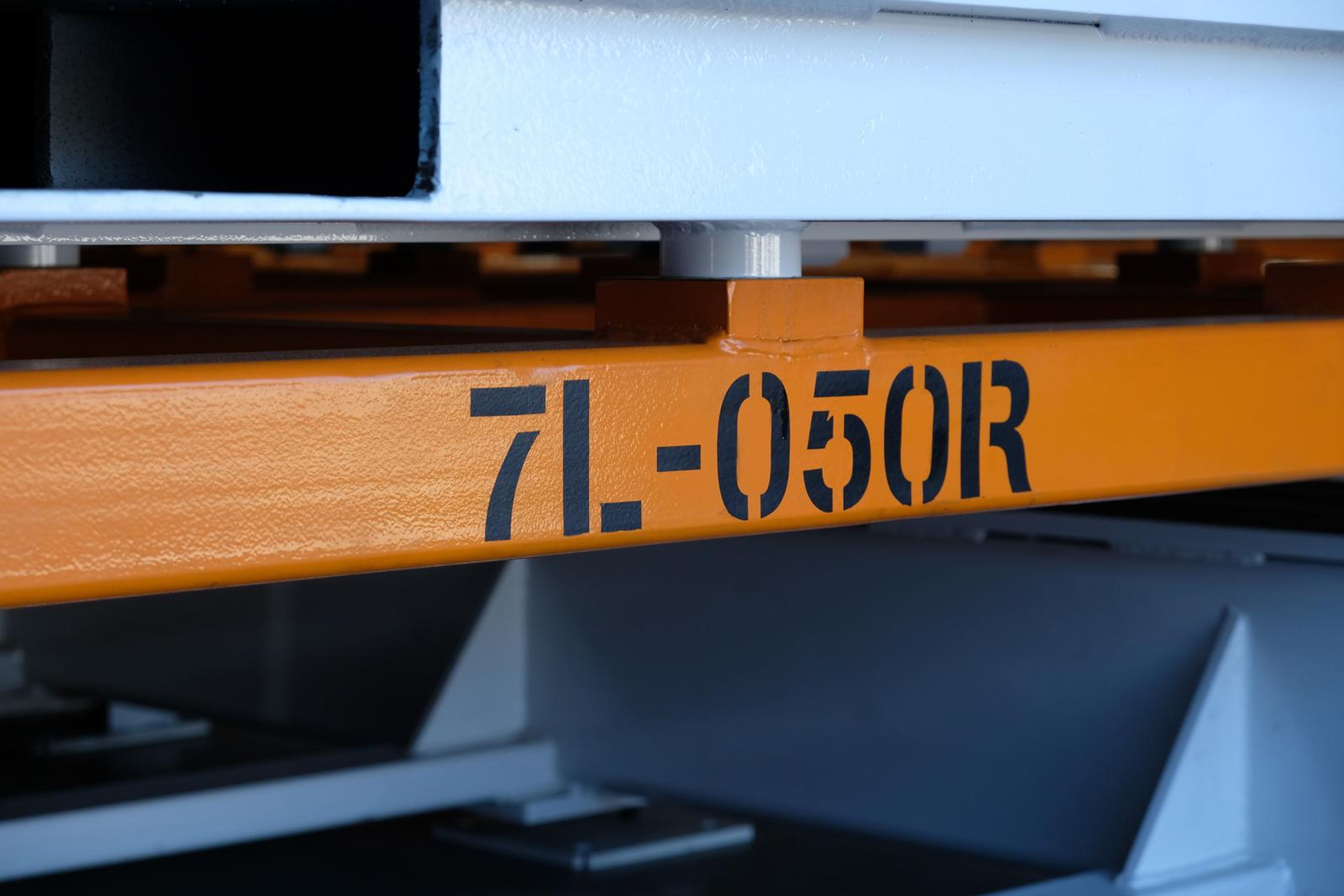 Orange beam stencilled 7L-050R above white supports