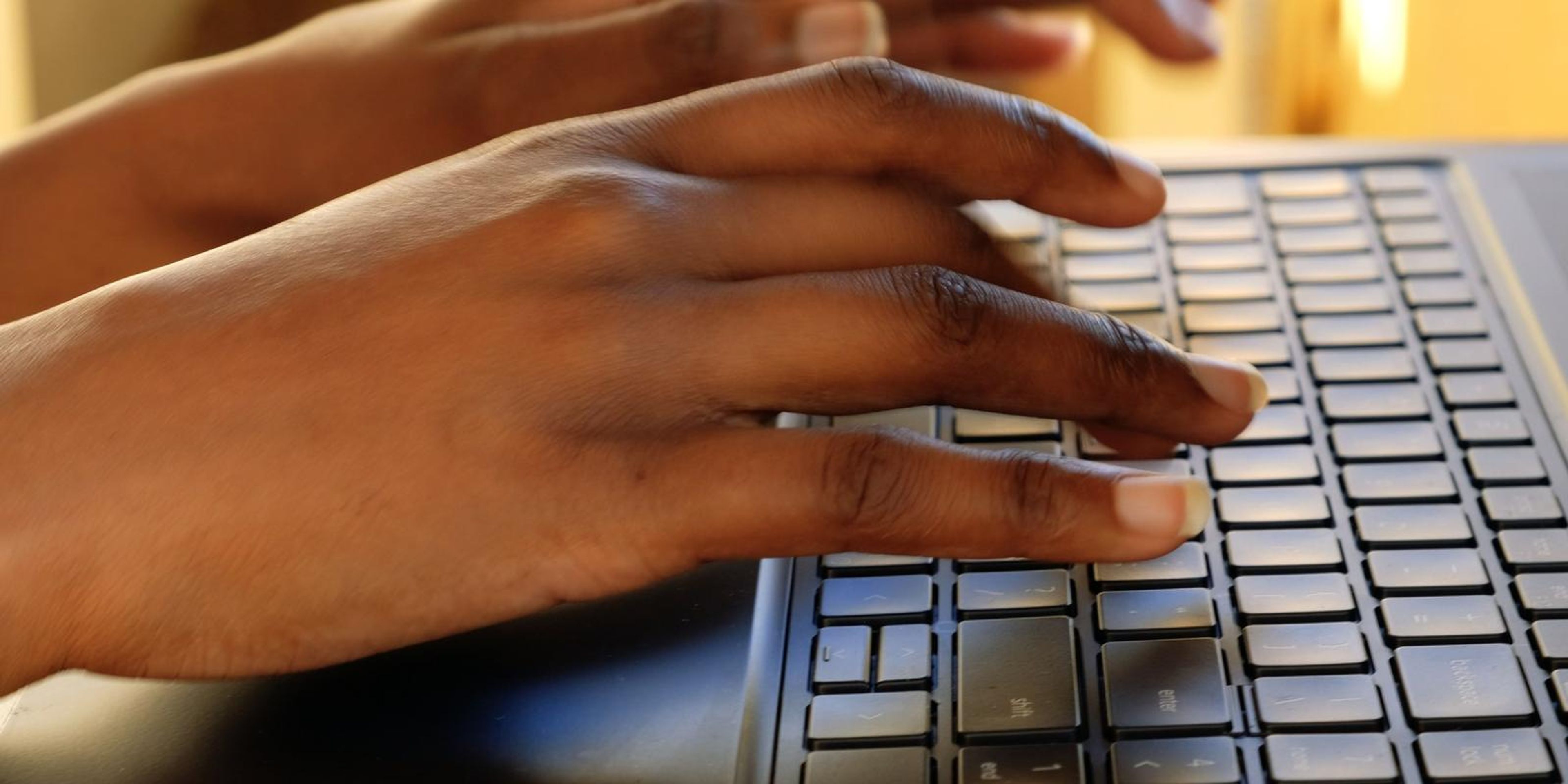Frame of a hand typing on a laptop keyboard