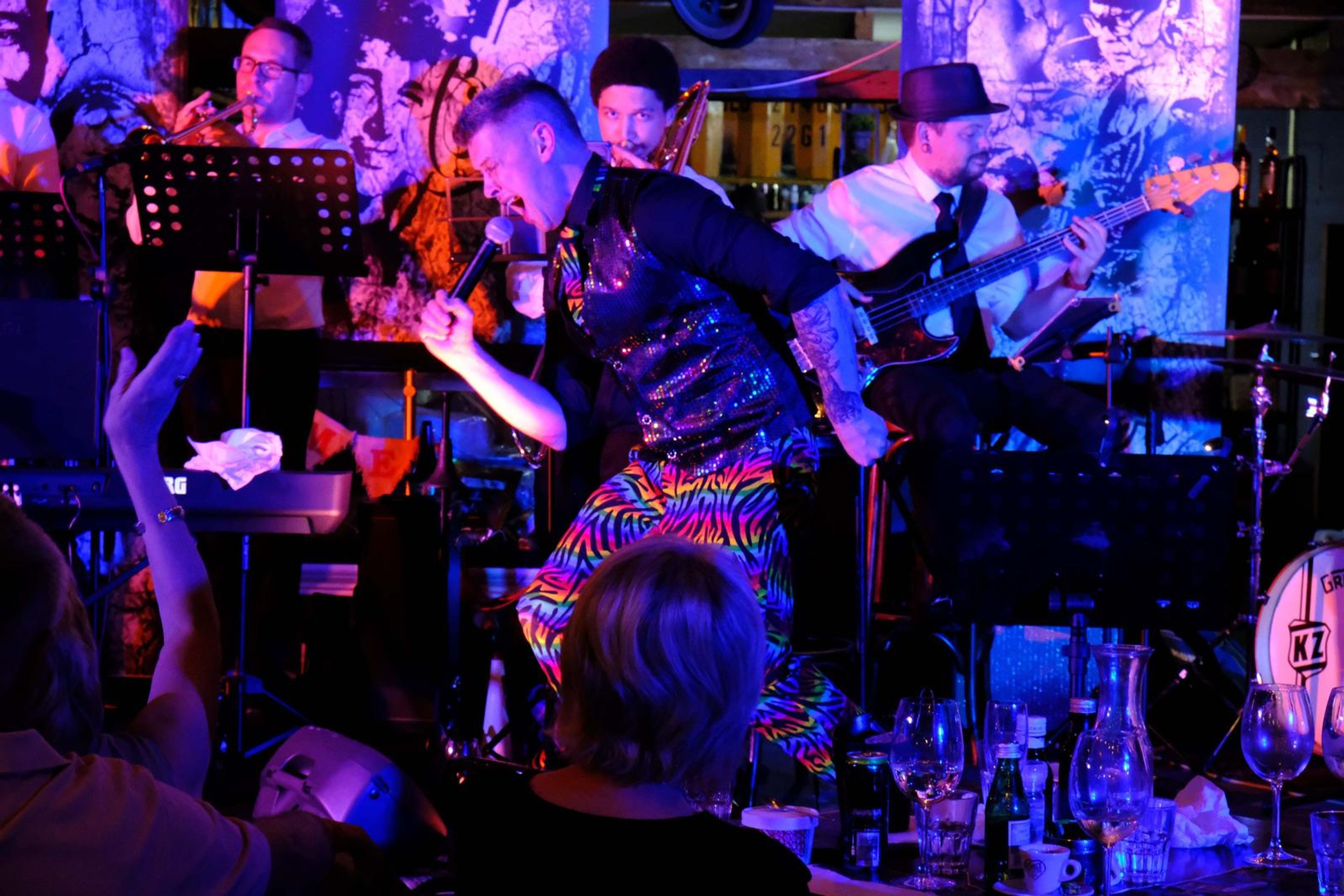 Singer in rainbow trousers dancing on stage