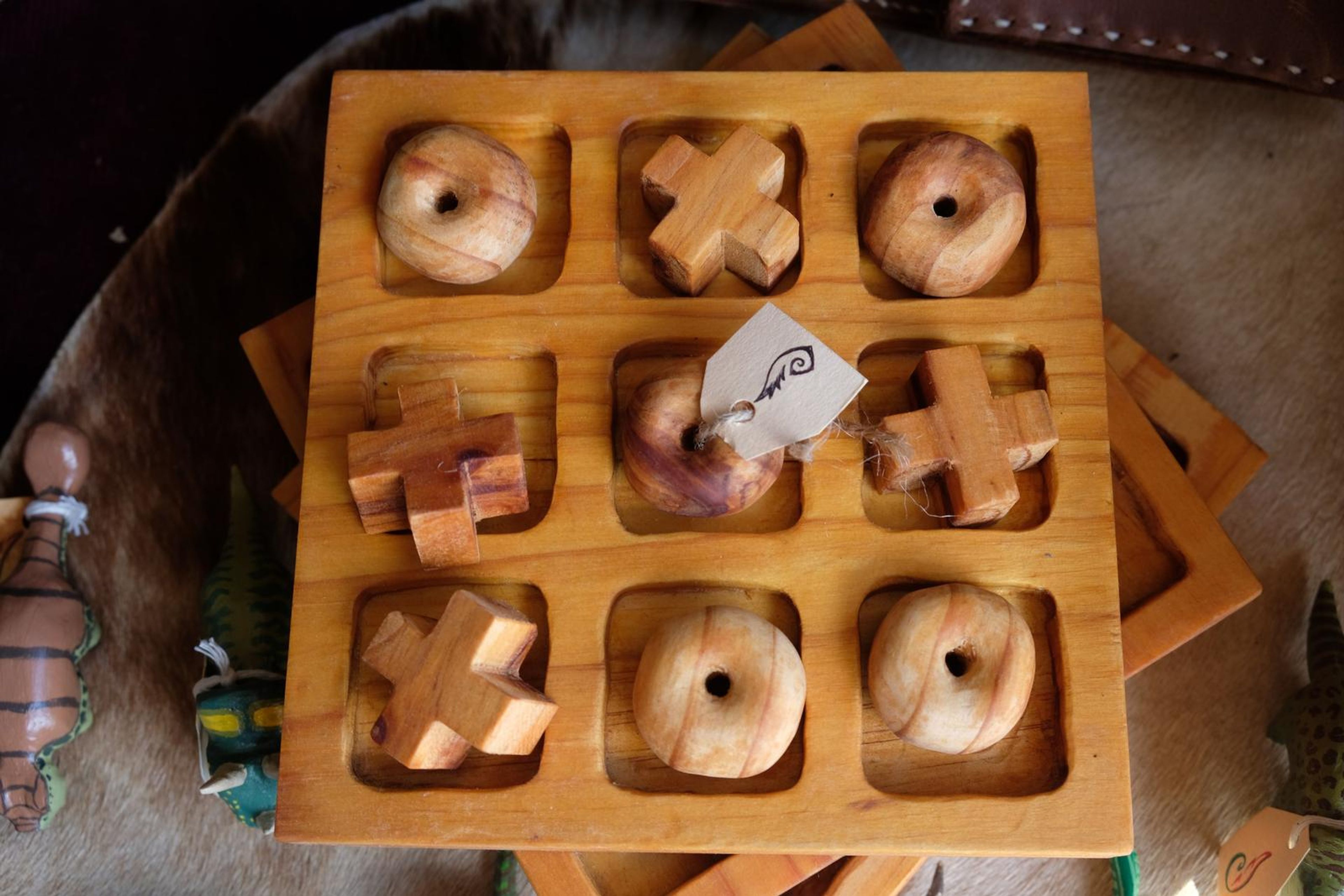 Hand-carved wooden tic-tac-toe board with carved pieces
