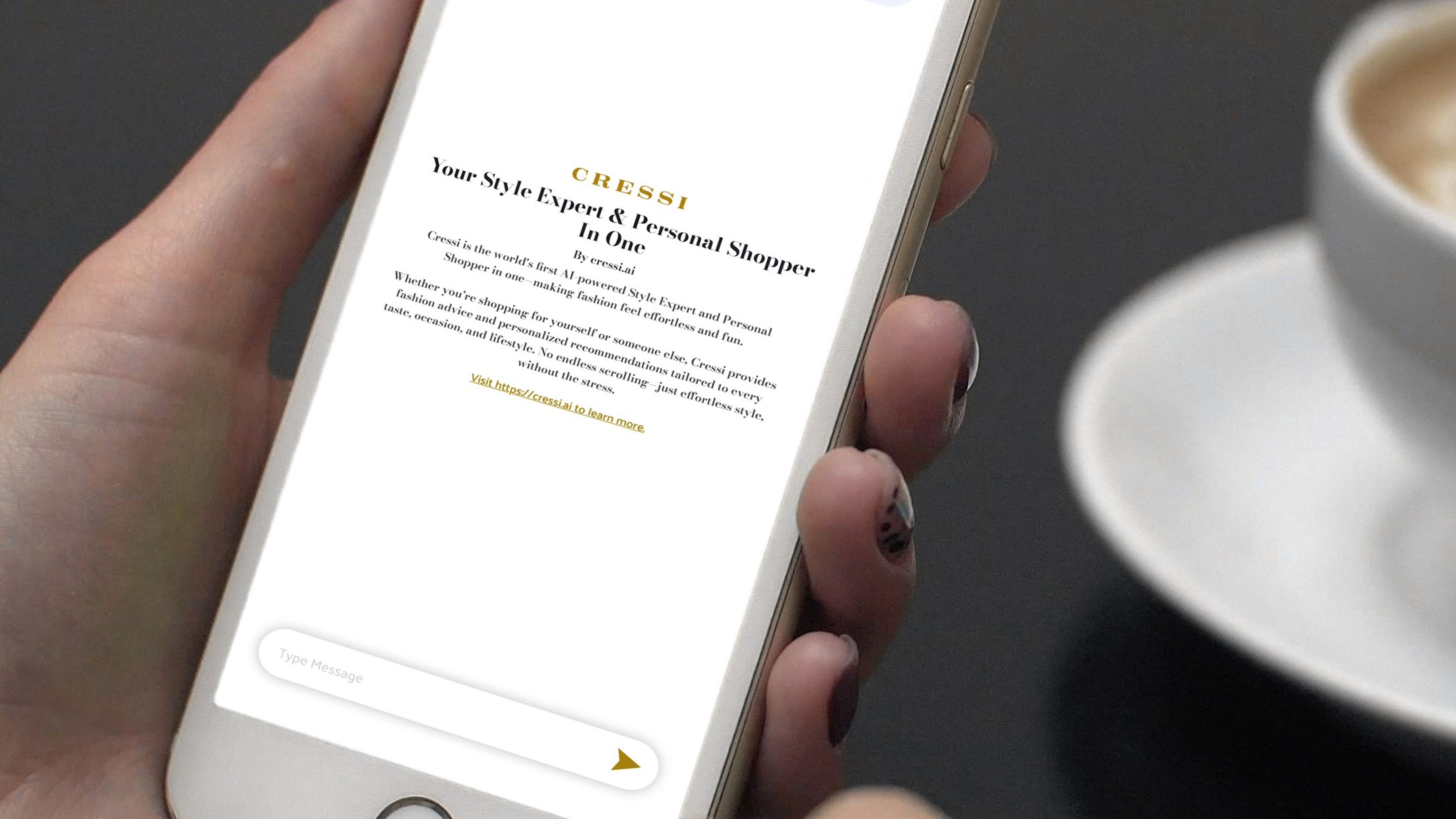 Hand holding a phone showing the CRESSI chat beside a coffee cup