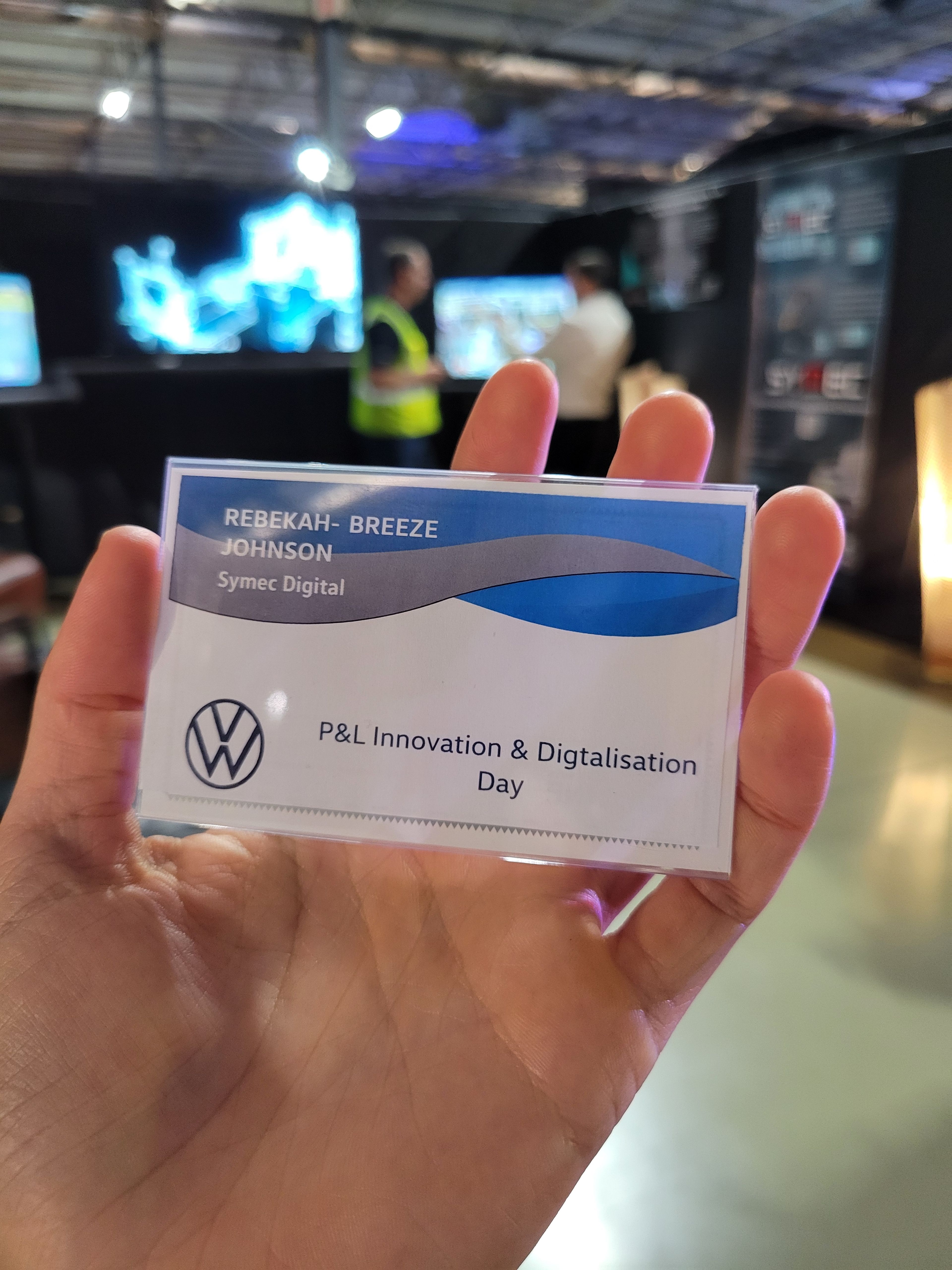 Behind the scenes, a name badge held up for the Volkswagen Innovation and Digitalisation Day