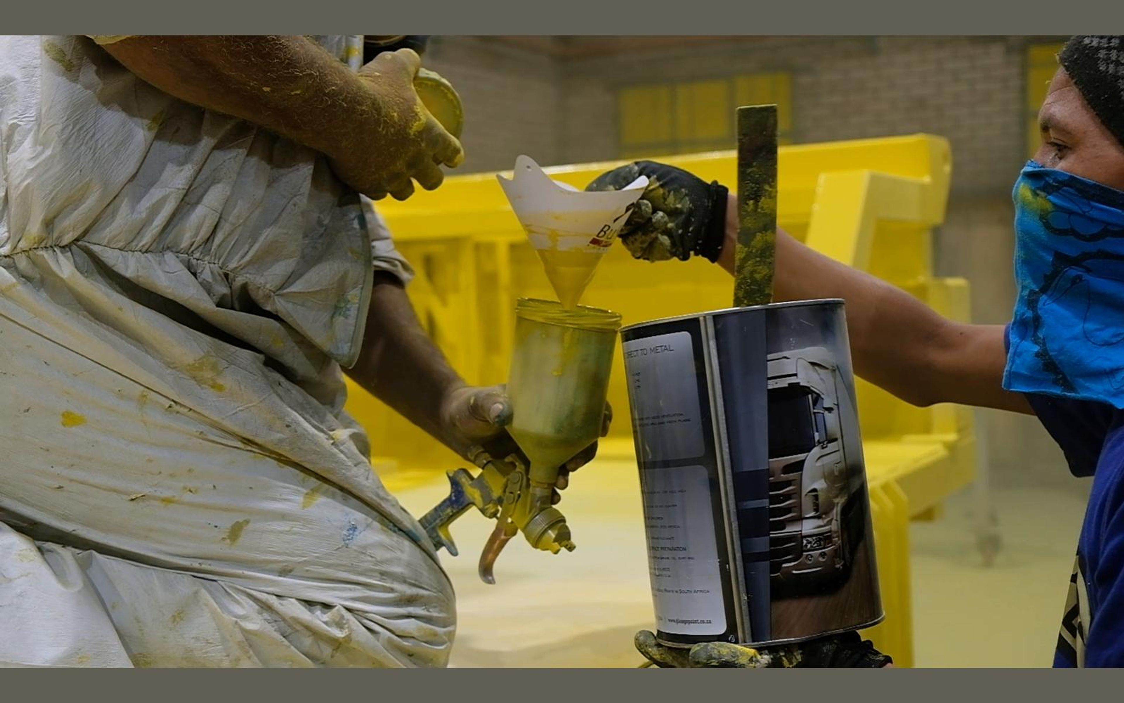 Painter spraying a yellow frame