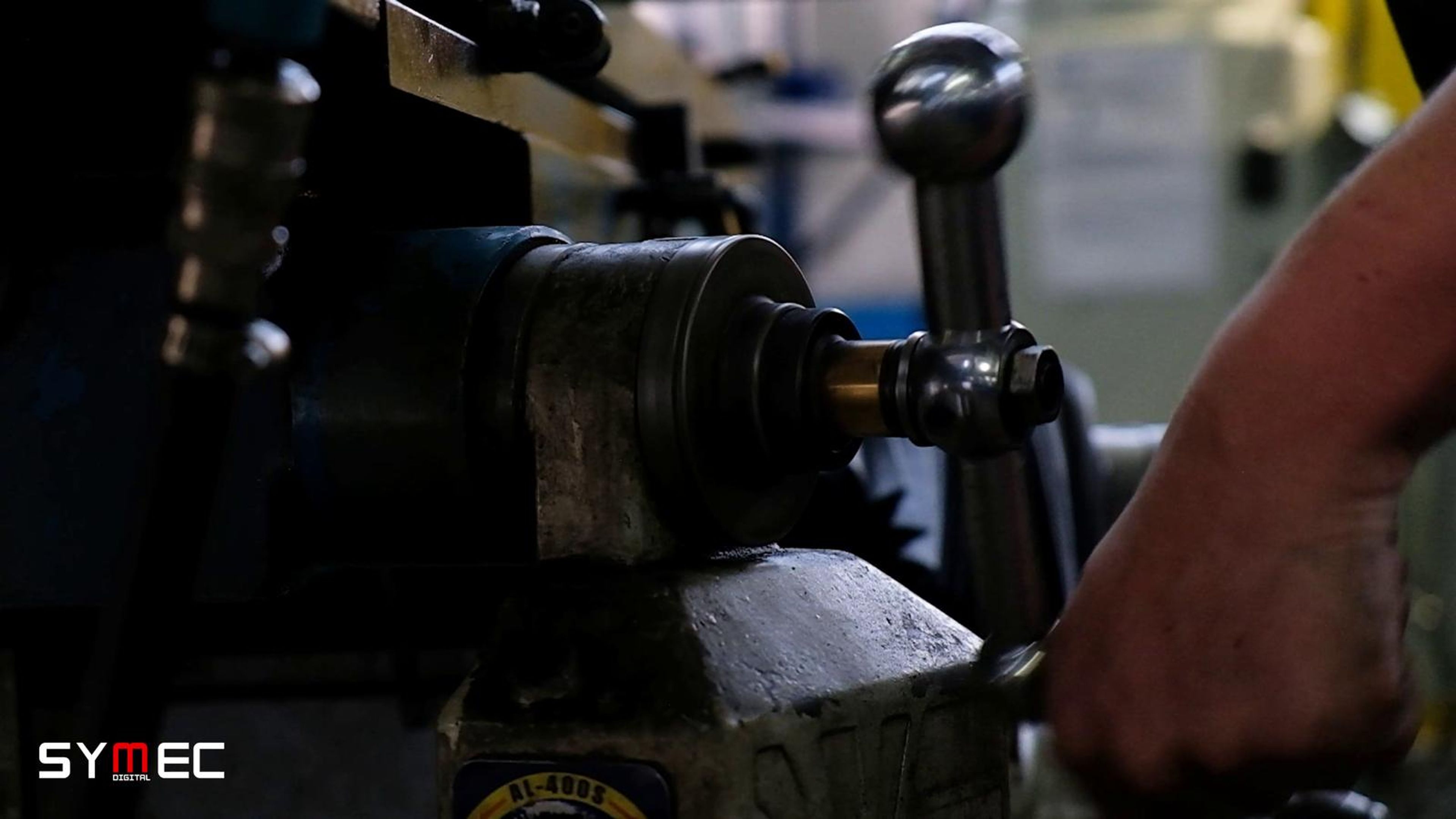 Hand adjusting a lathe in close view