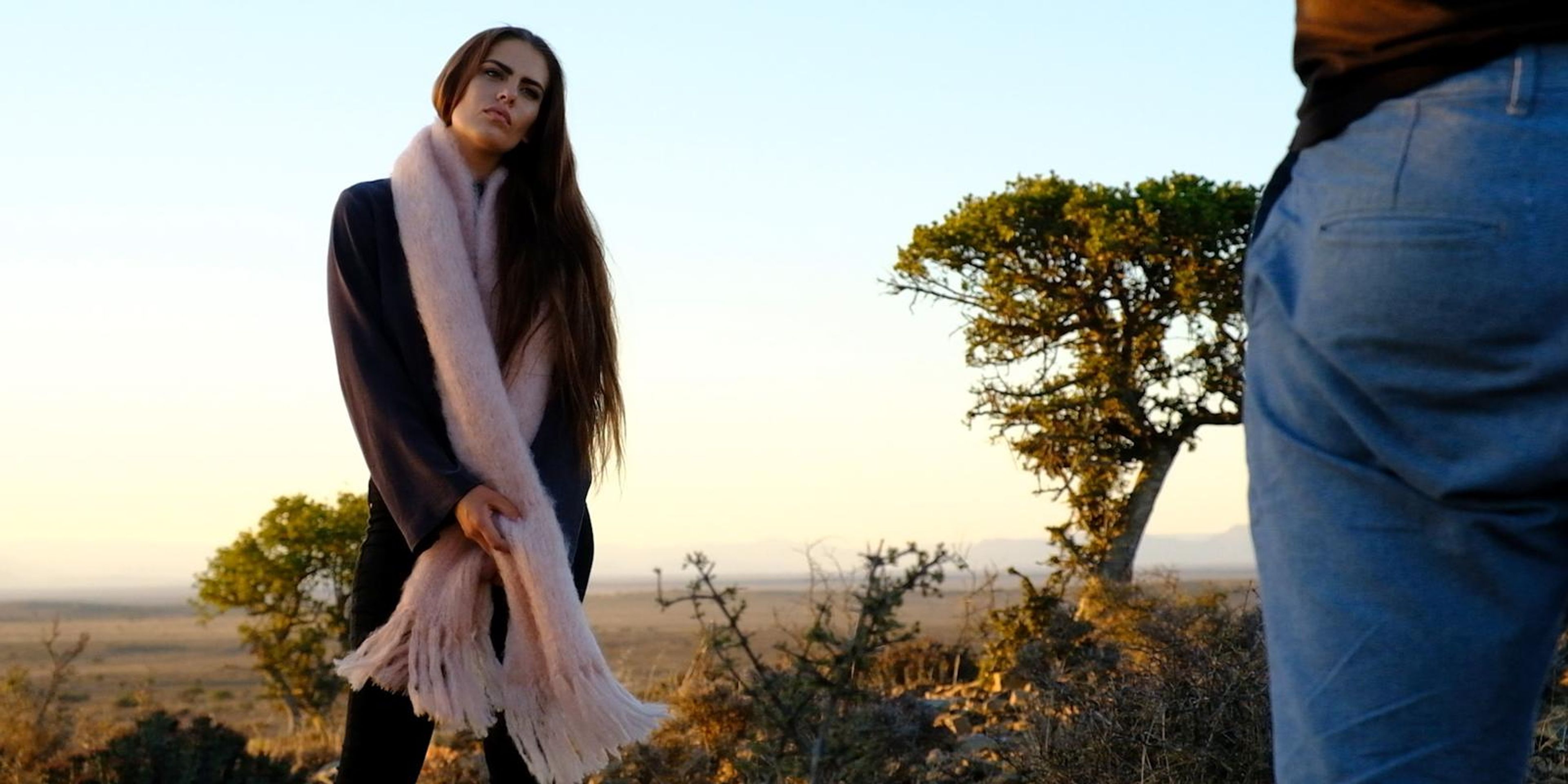 Model wrapped in a long pink mohair scarf at sunset