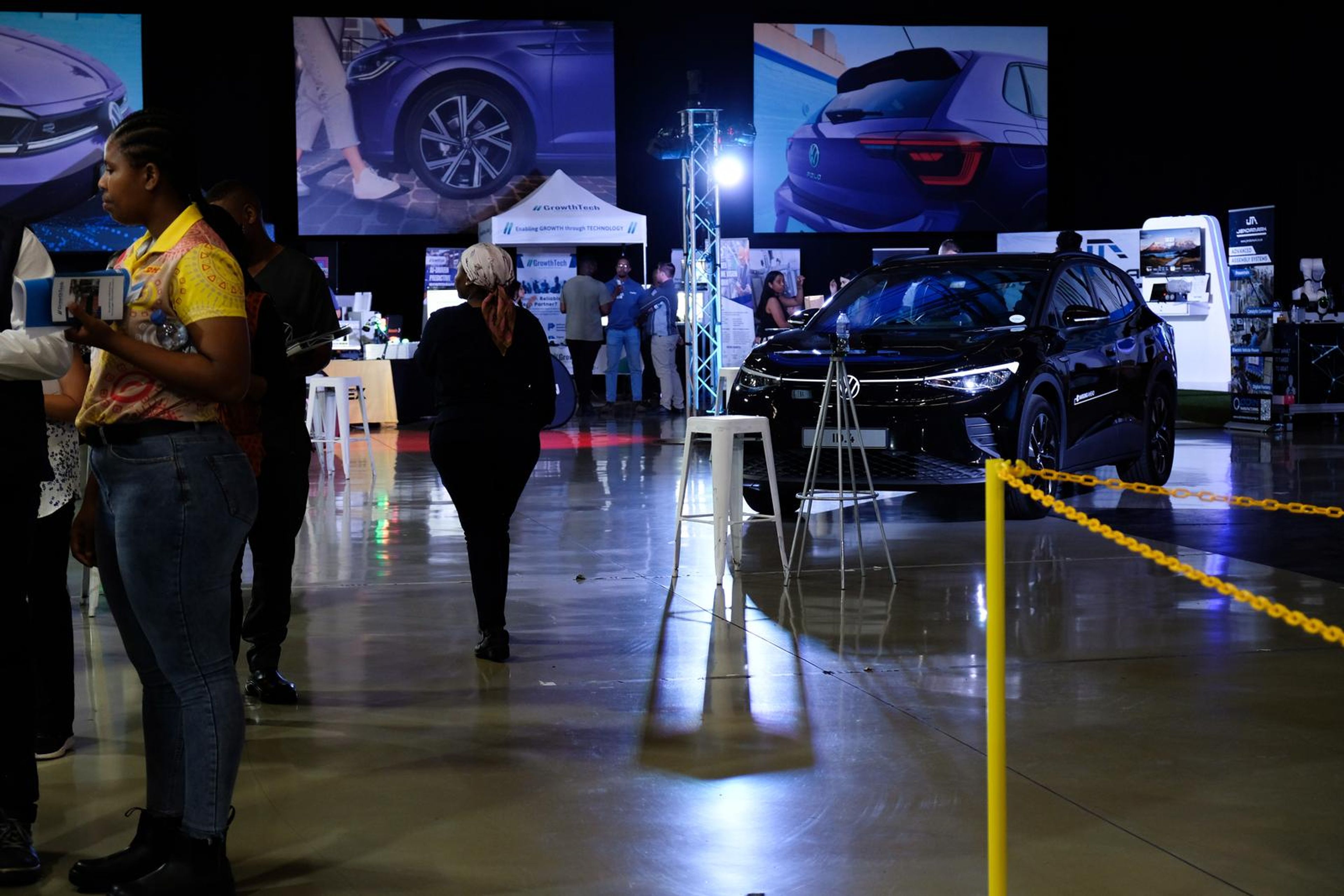 Visitors walking past a Volkswagen on display in the expo hall