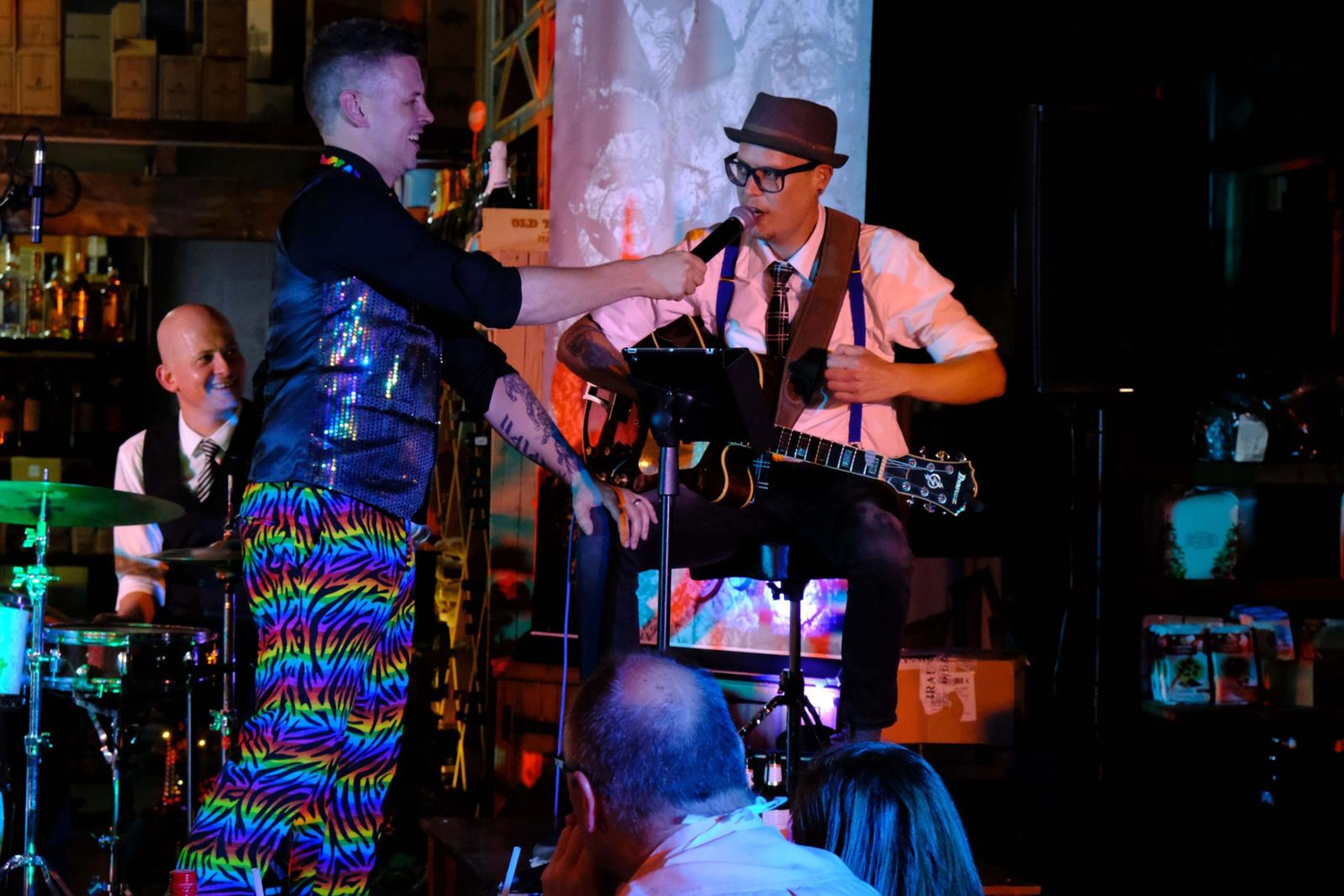 Singer and guitarist in a hat sharing a moment on stage