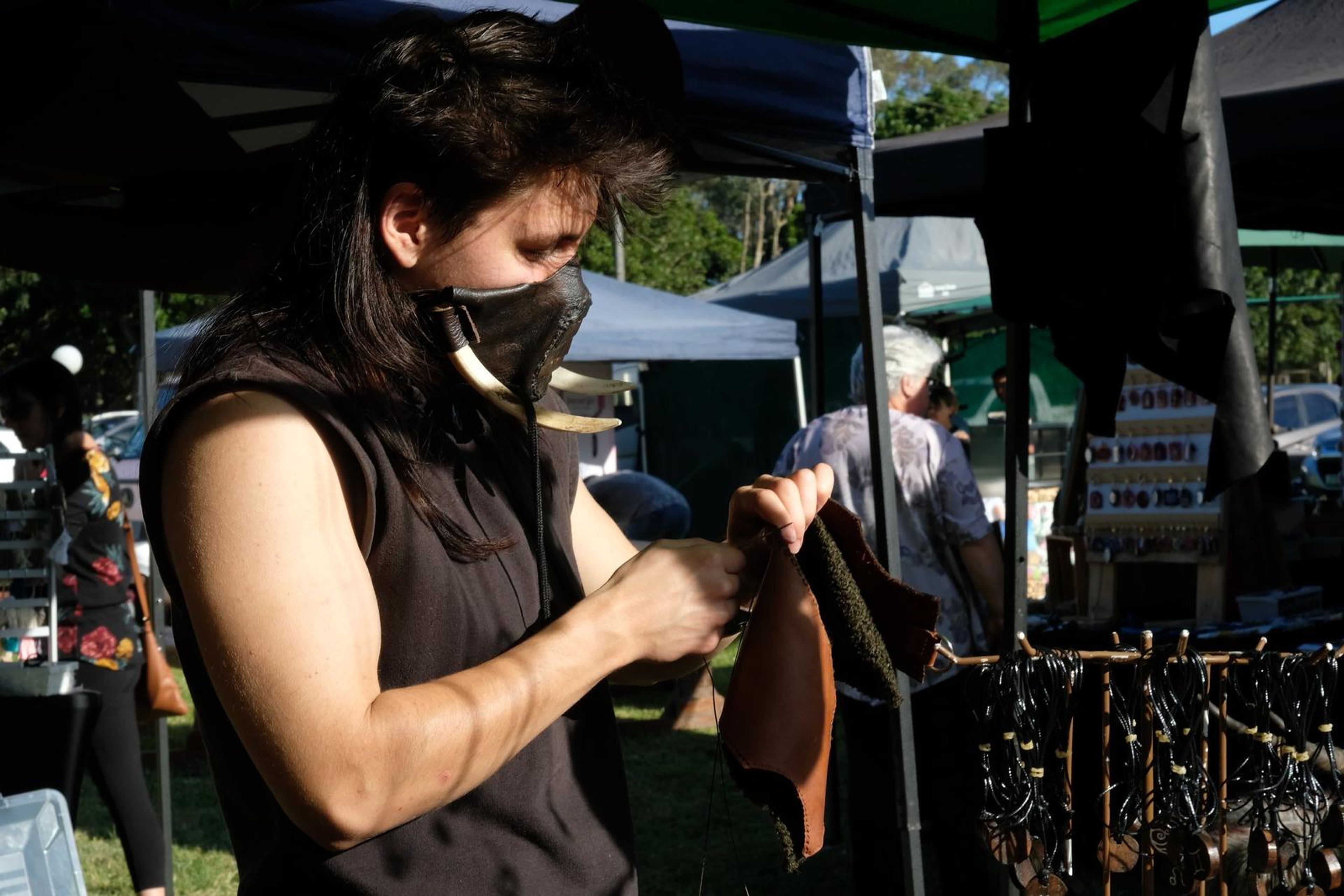 Juuks maker holding a piece of tan leather at the stall