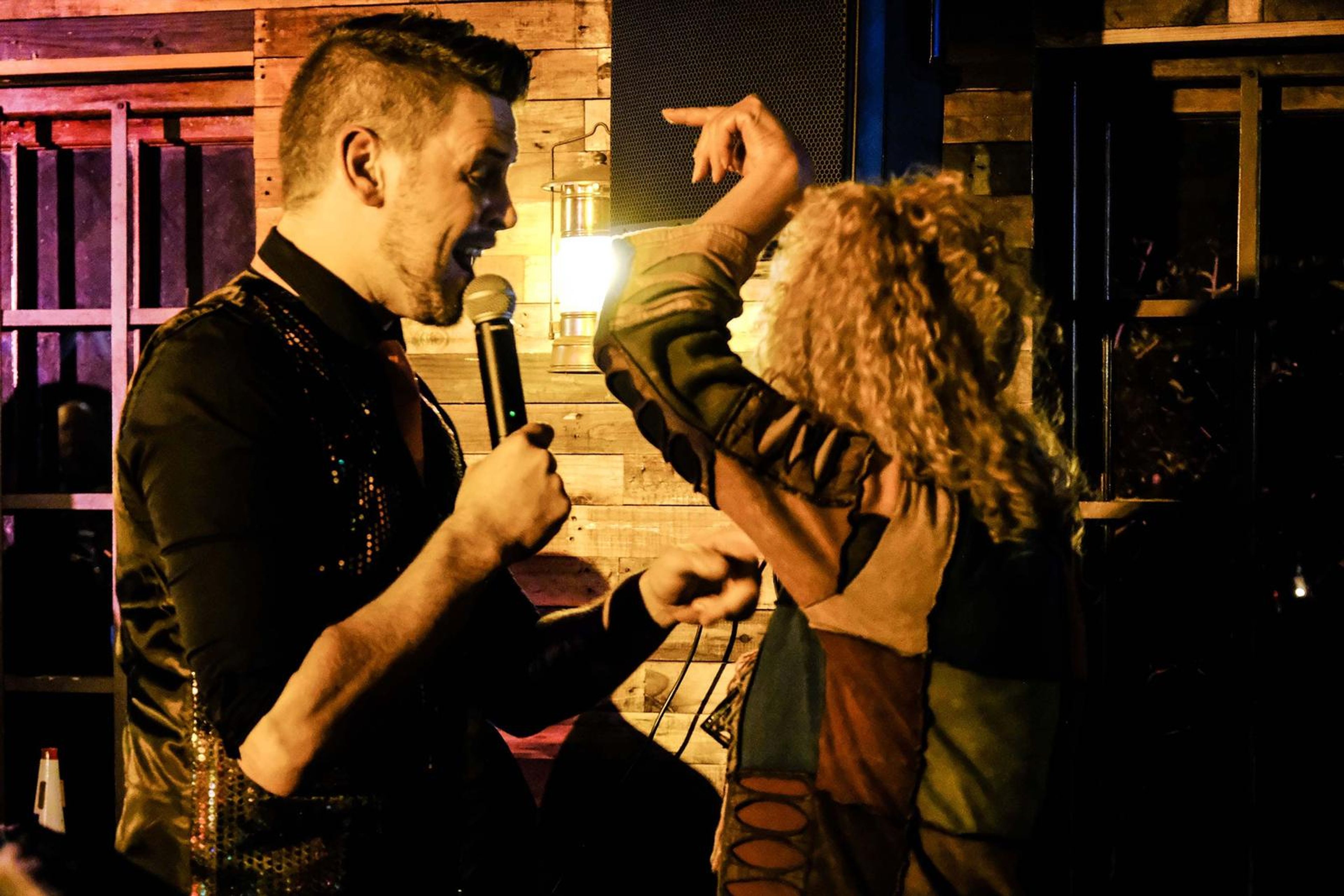 Lead singer sharing a microphone with a guest who dances beside him