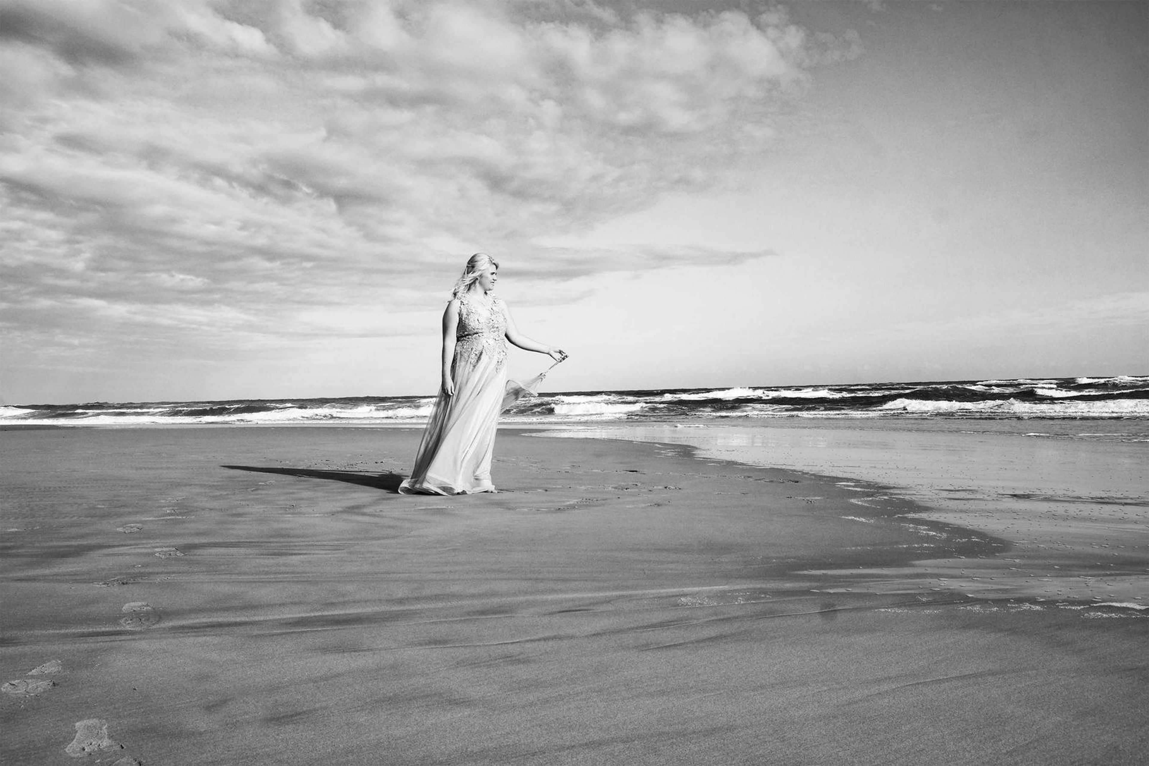 Black and white shoreline portrait with clouds overhead