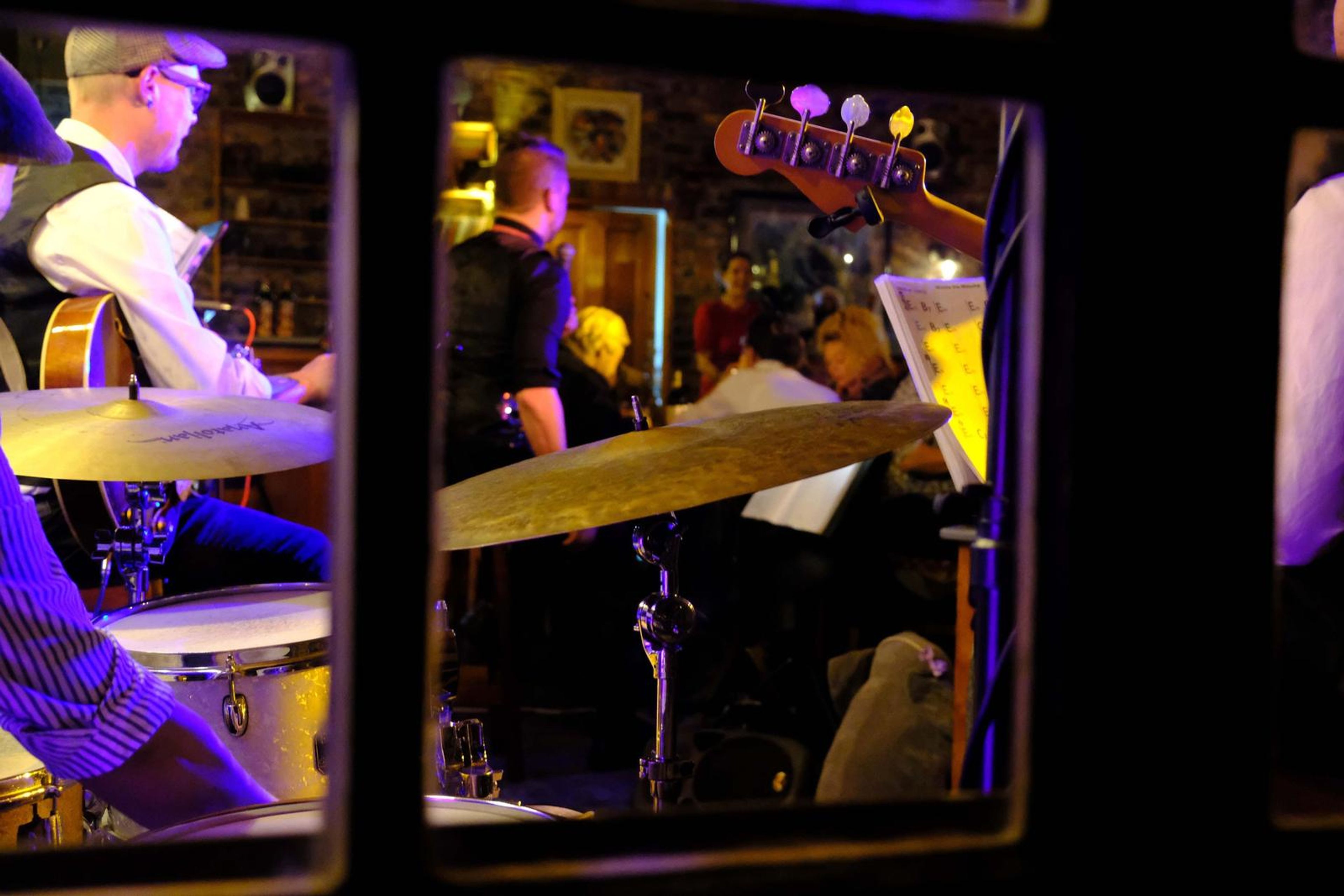 View of the drummer and band through a window
