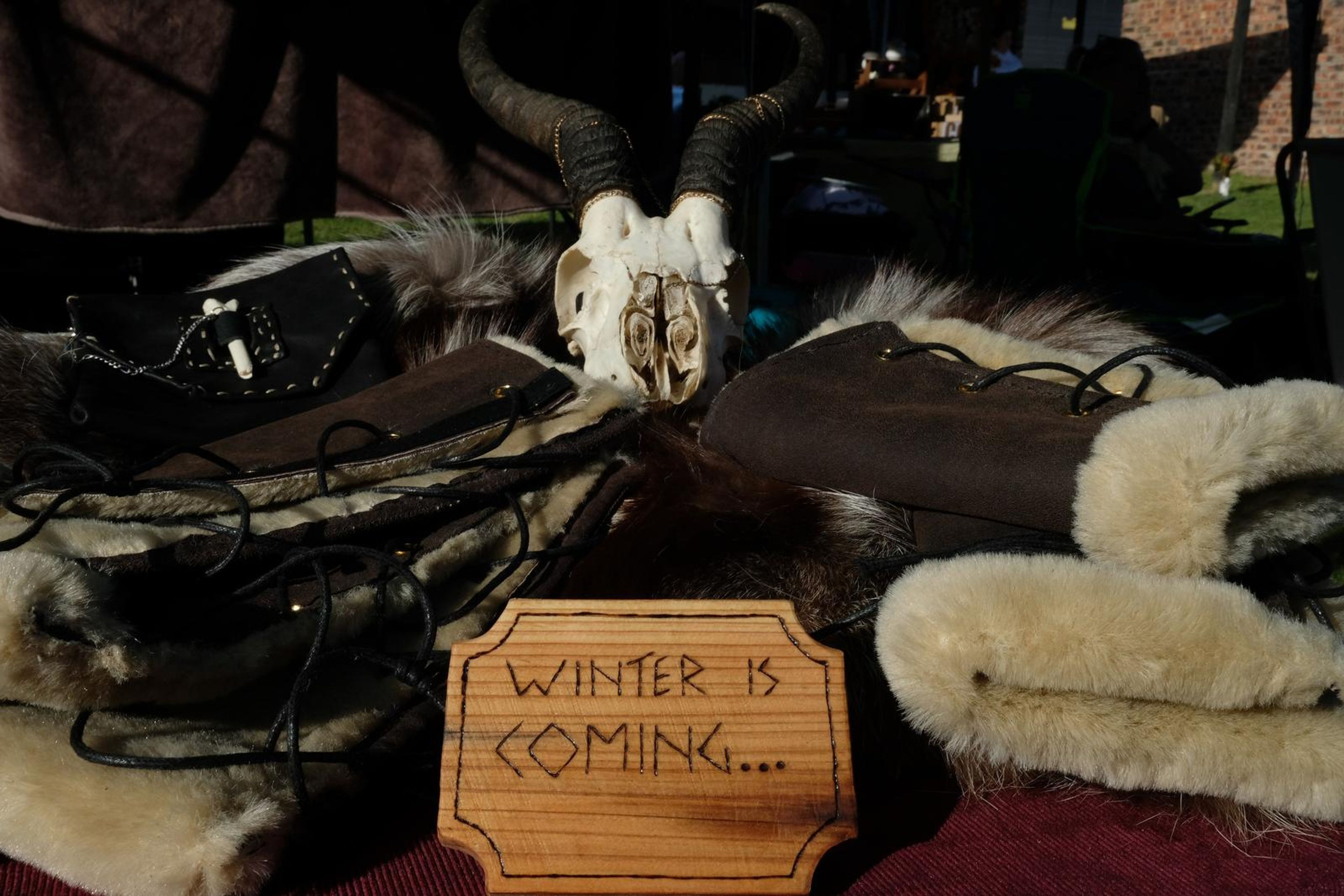 Fur-lined leather arm wraps with lacing, a Winter Is Coming sign and animal skull