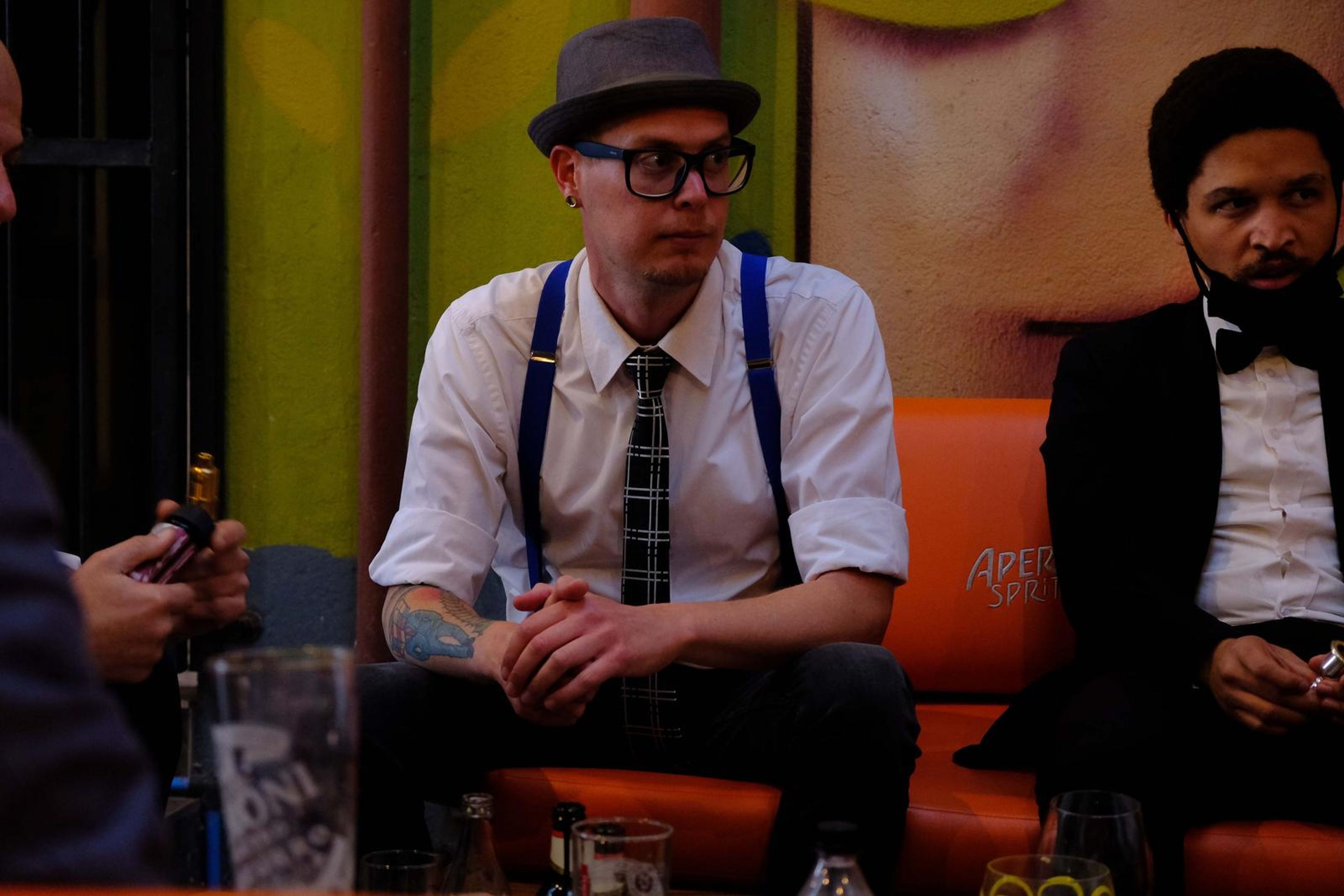 Band member in glasses and suspenders waiting backstage