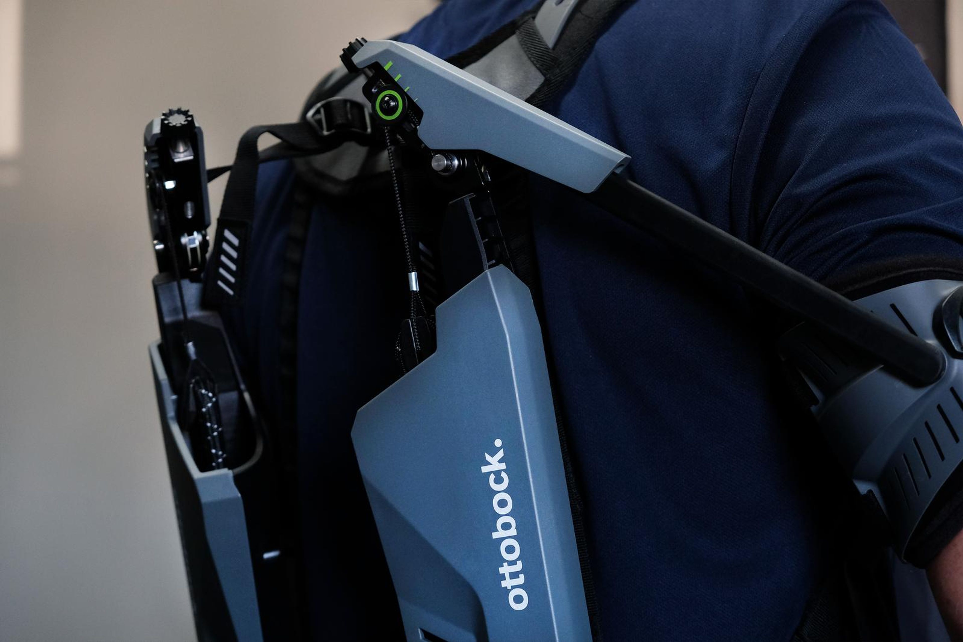 Exoskeleton arm support rising over a visitor's shoulder