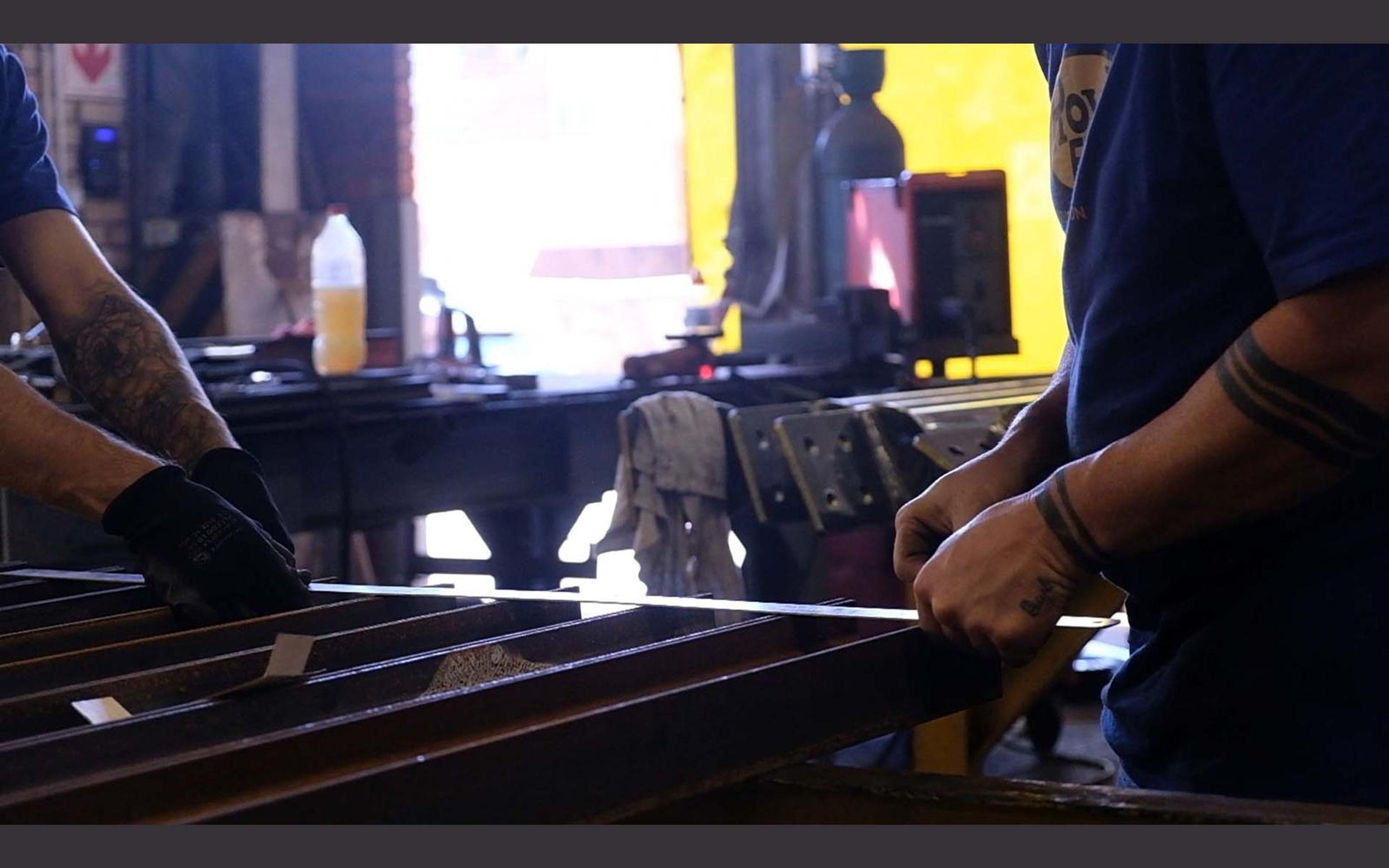 Hands working on a steel part in the fabrication sector