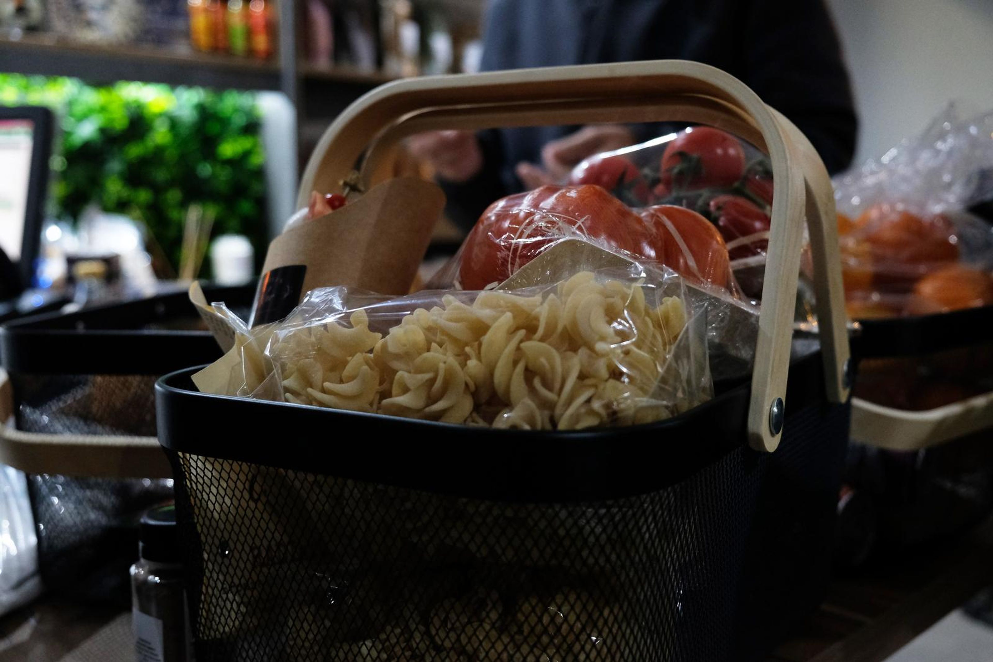 Close-up of a basket packed with pasta, tomatoes and a gift pack